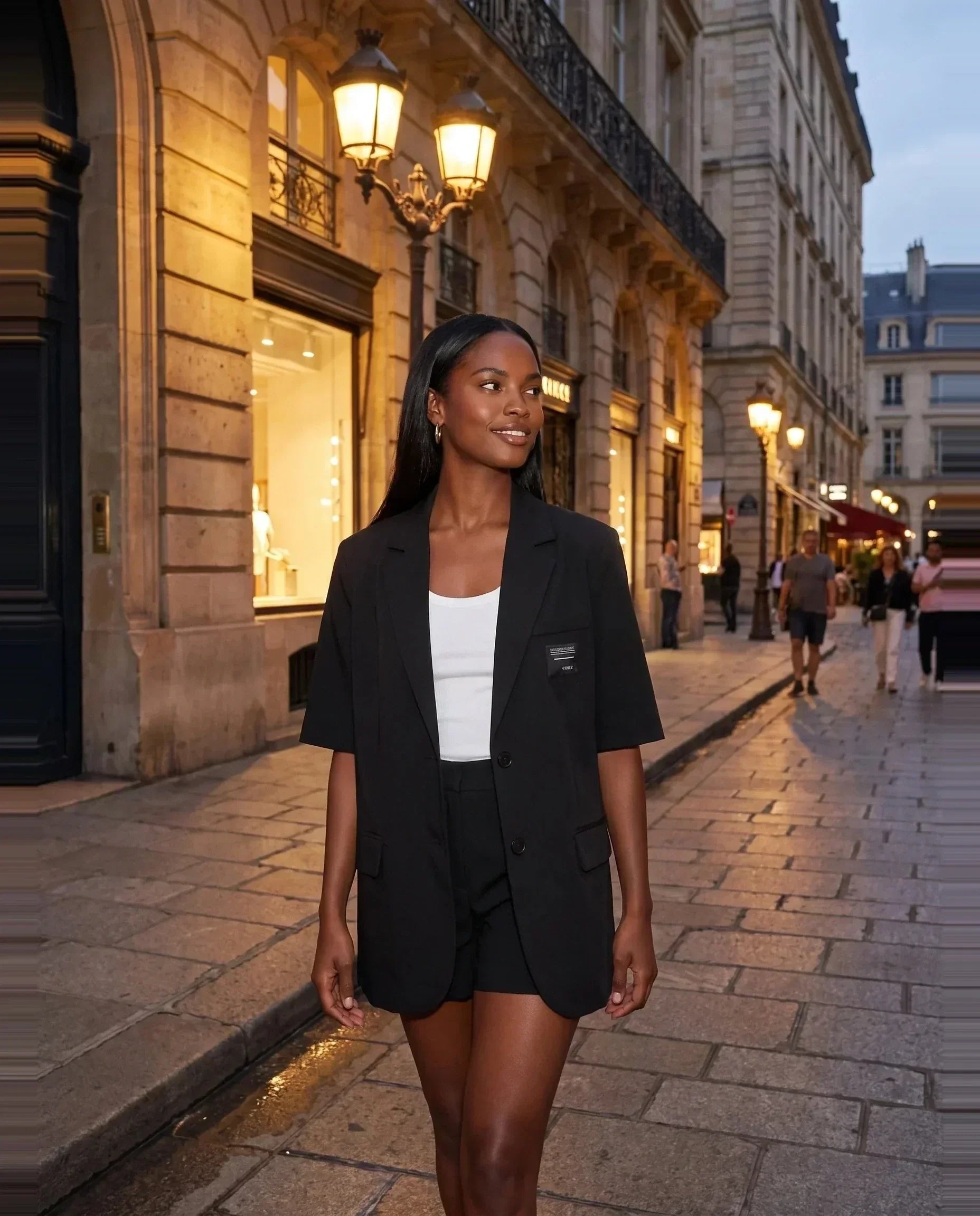 Blazer manches courtes noir Arlette, porté dans une rue élégante le soir
