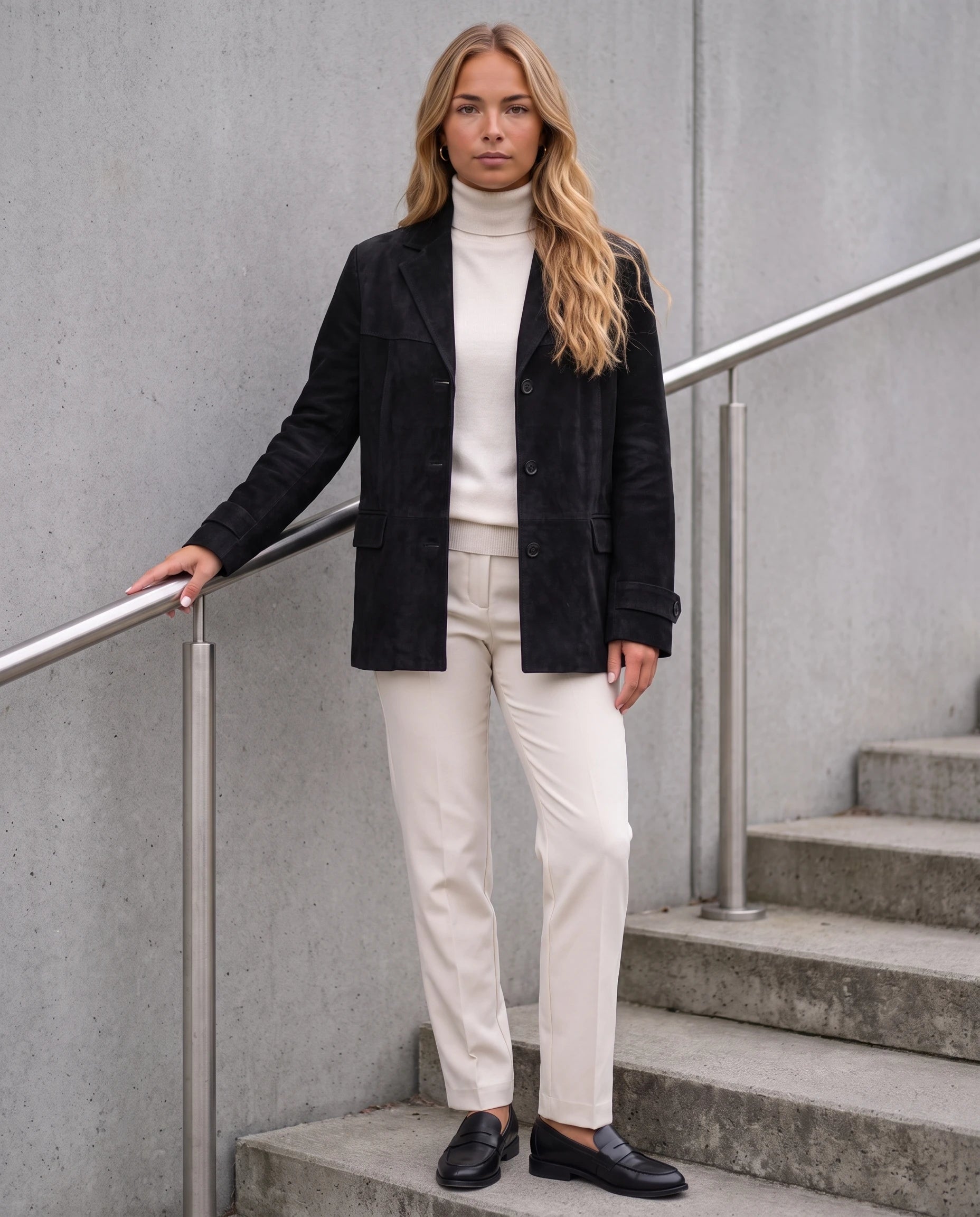 Blazer en suédine noir Prisca, porté sur un escalier extérieur