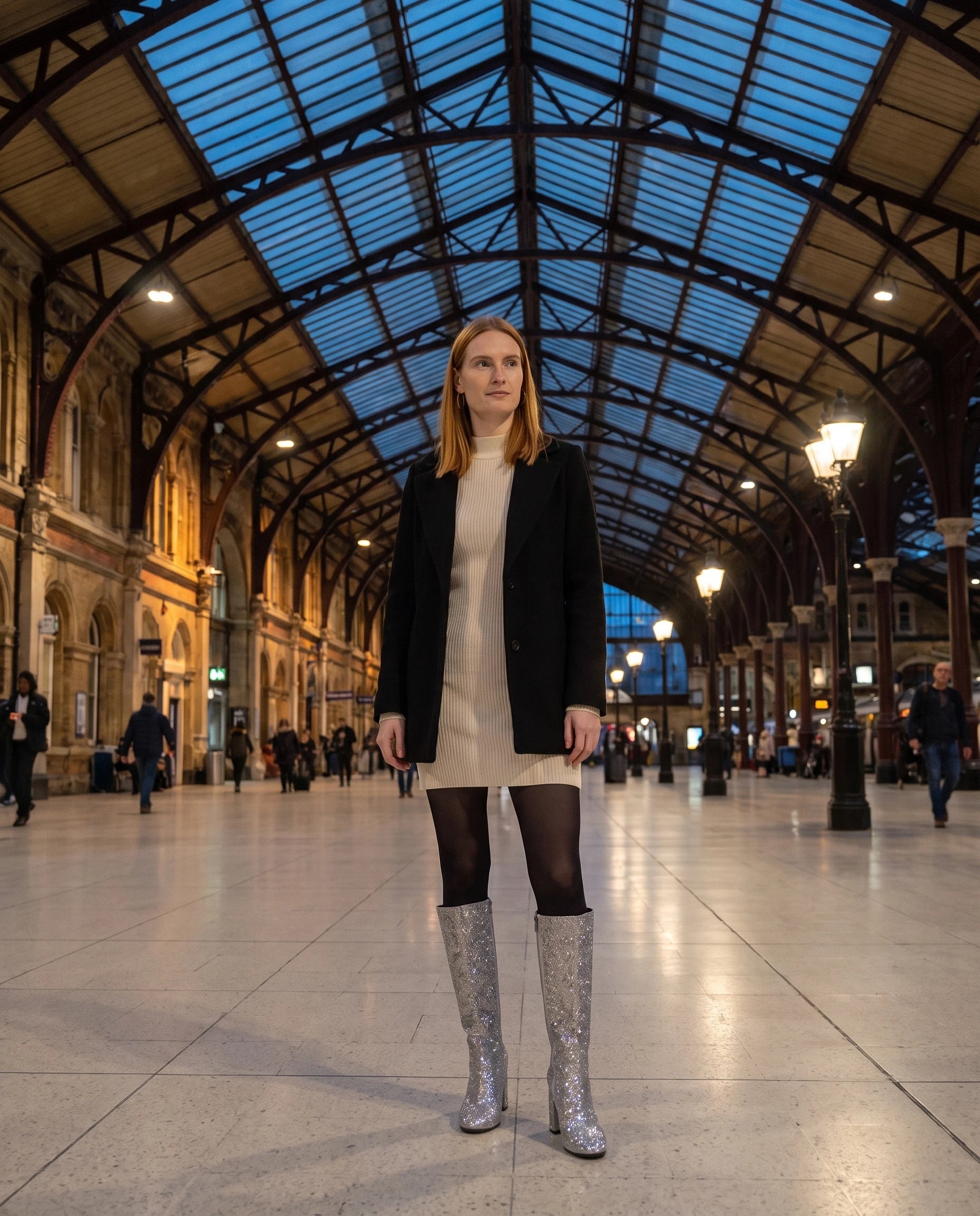 Bottes hautes à paillettes à talon large Éliette — Argent, portées dans un hall de gare sous verrière