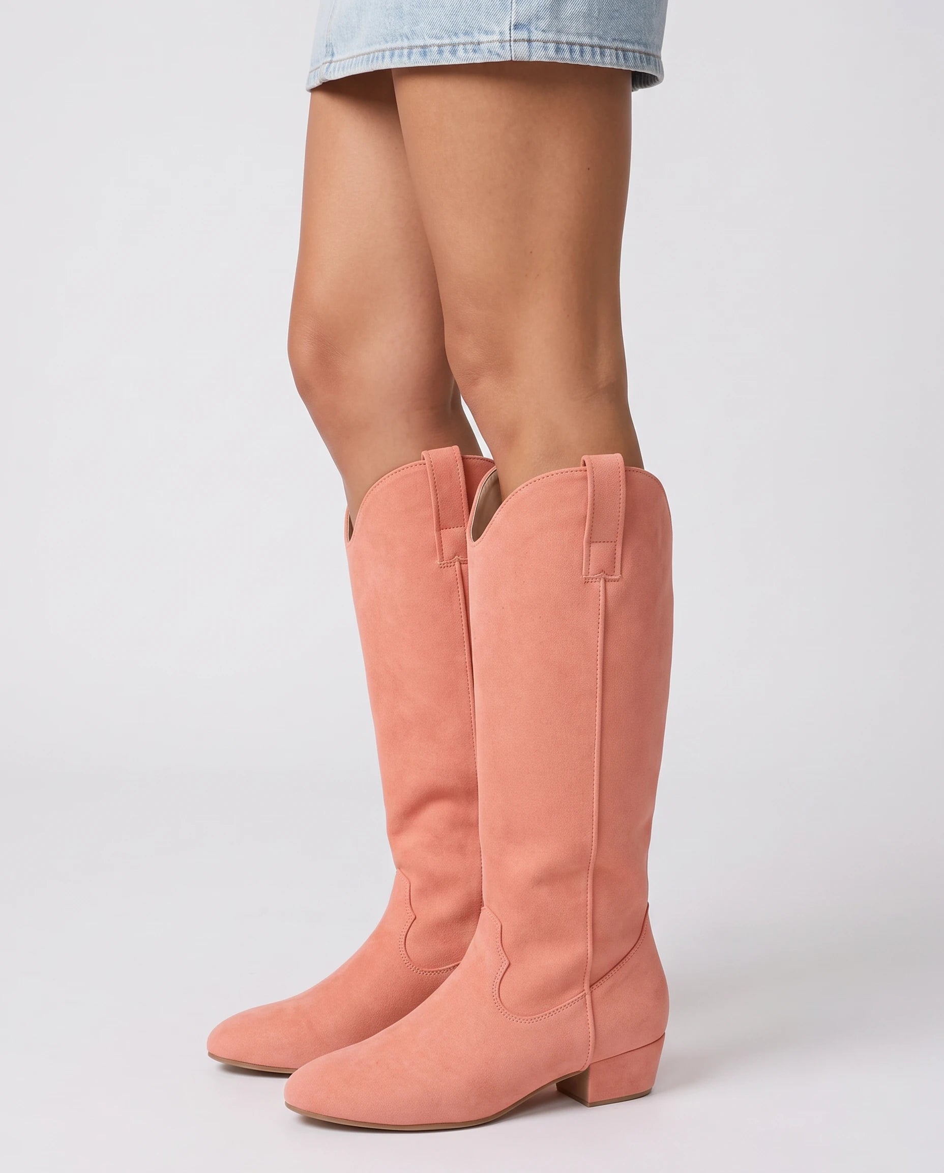 Bottes hautes western en suédine Marjolaine — Corail, portées en plan rapproché vues de profil
