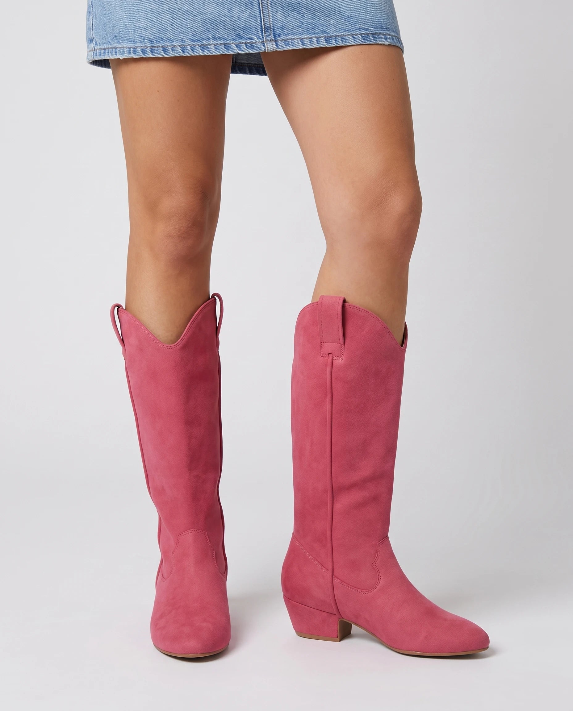 Bottes hautes western en suédine Marjolaine — Rose Framboise, portées en plan rapproché avec une robe courte