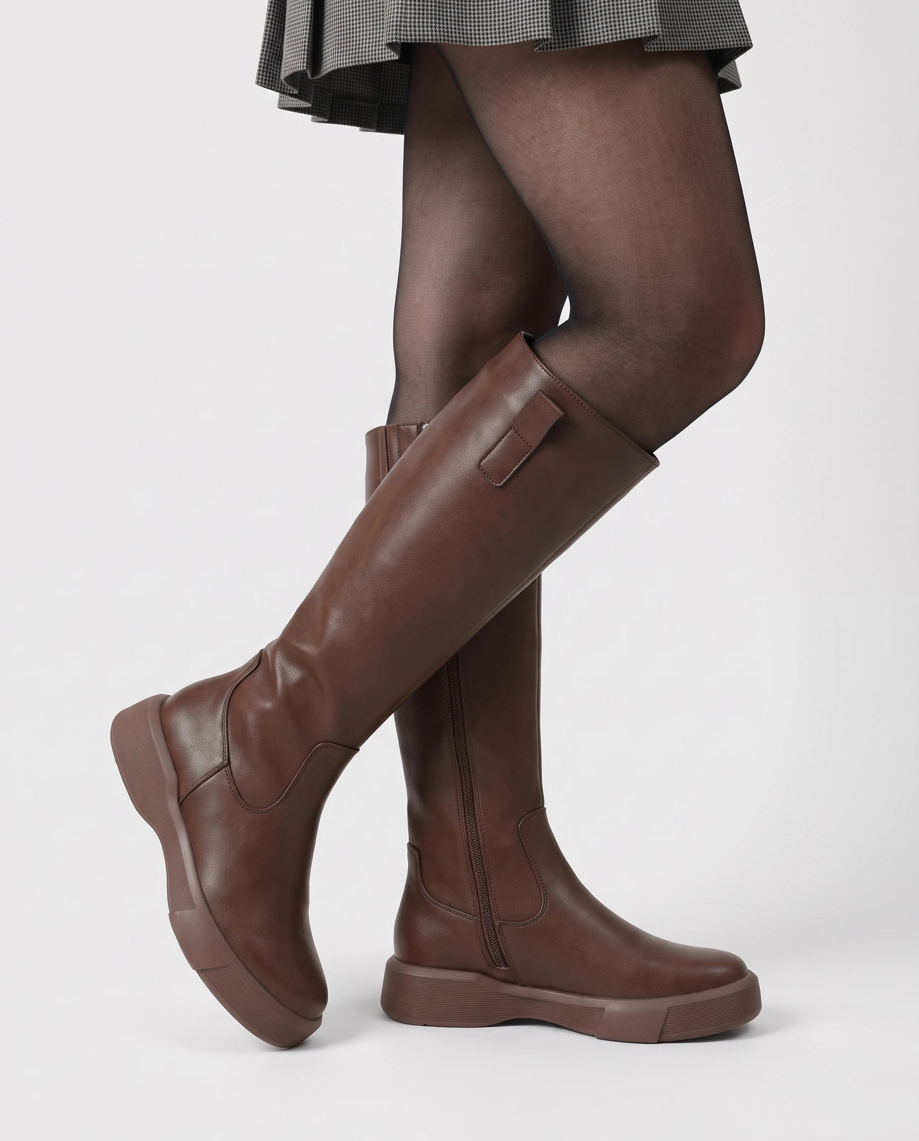 Bottes hautes zippées à semelle épaisse Justine — Chocolat, portées en plan rapproché avec une jupe plissée