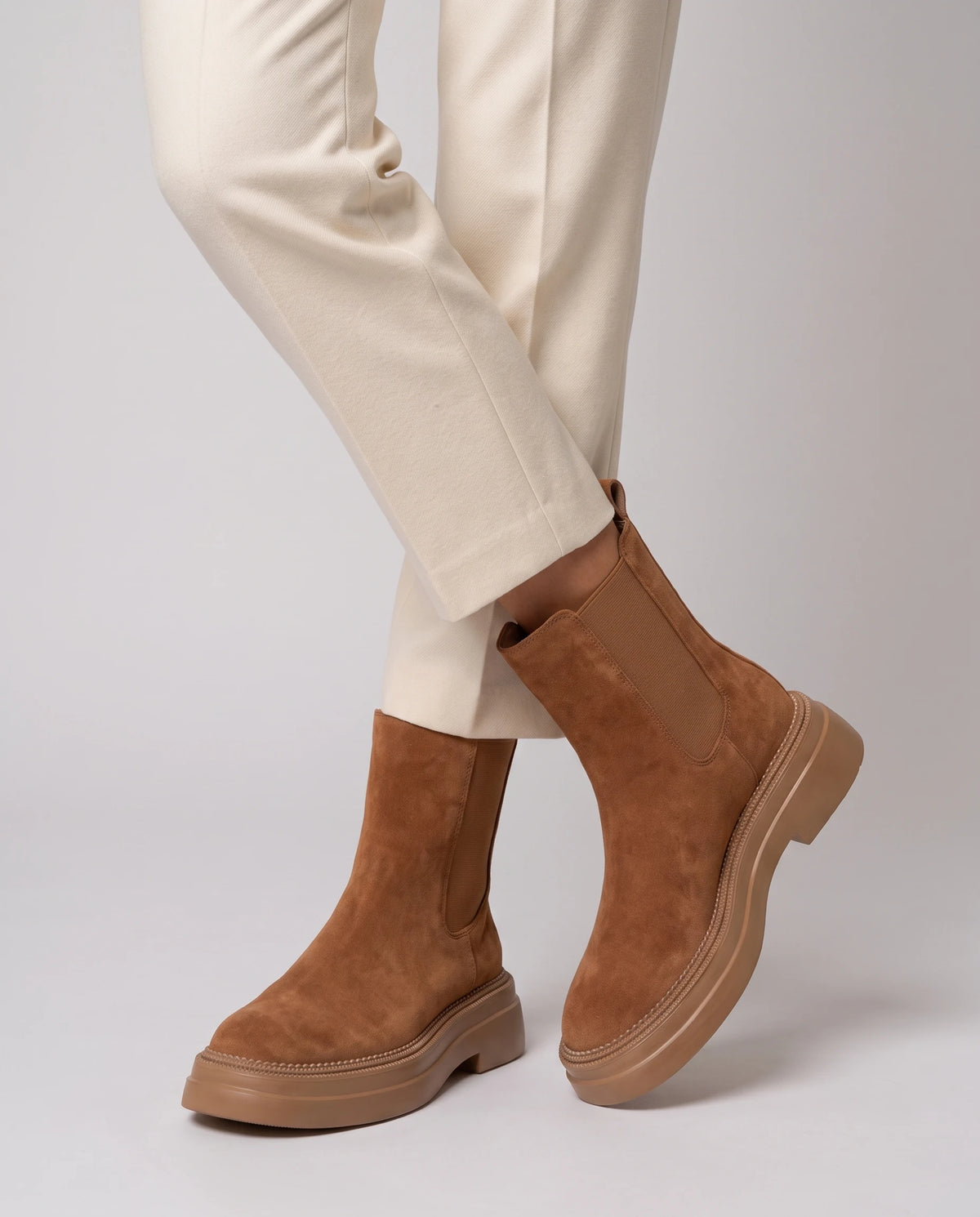 Chelsea Boots in Wildlederoptik Améline — Camel, in Nahaufnahme mit überkreuzten Knöcheln getragen