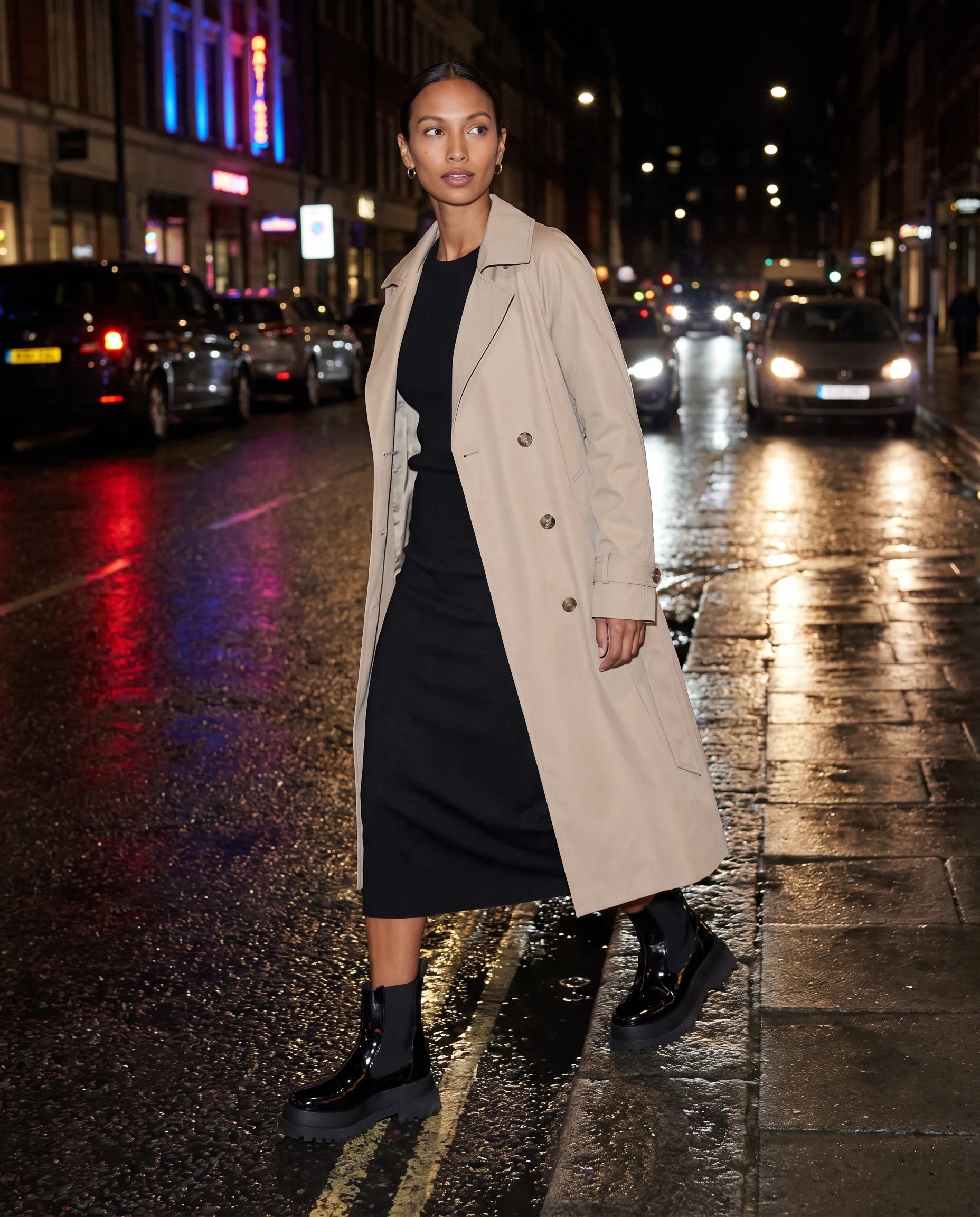 Bottines chelsea vernies à plateforme Gaëlle — Noir Verni, portées sur un trottoir mouillé le soir