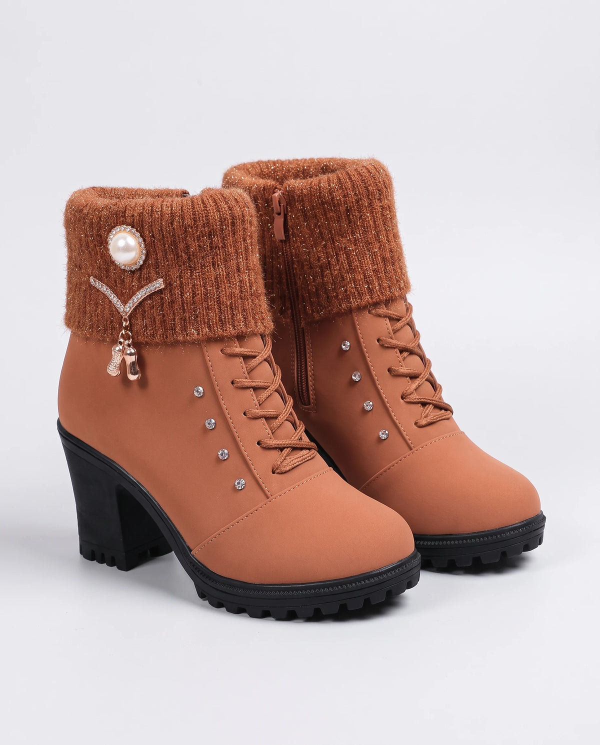 Bottines fourrées à talon et revers en maille Lucrèce — Cognac, paire vue de trois quarts studio, revers en maille rousse et breloque perle
