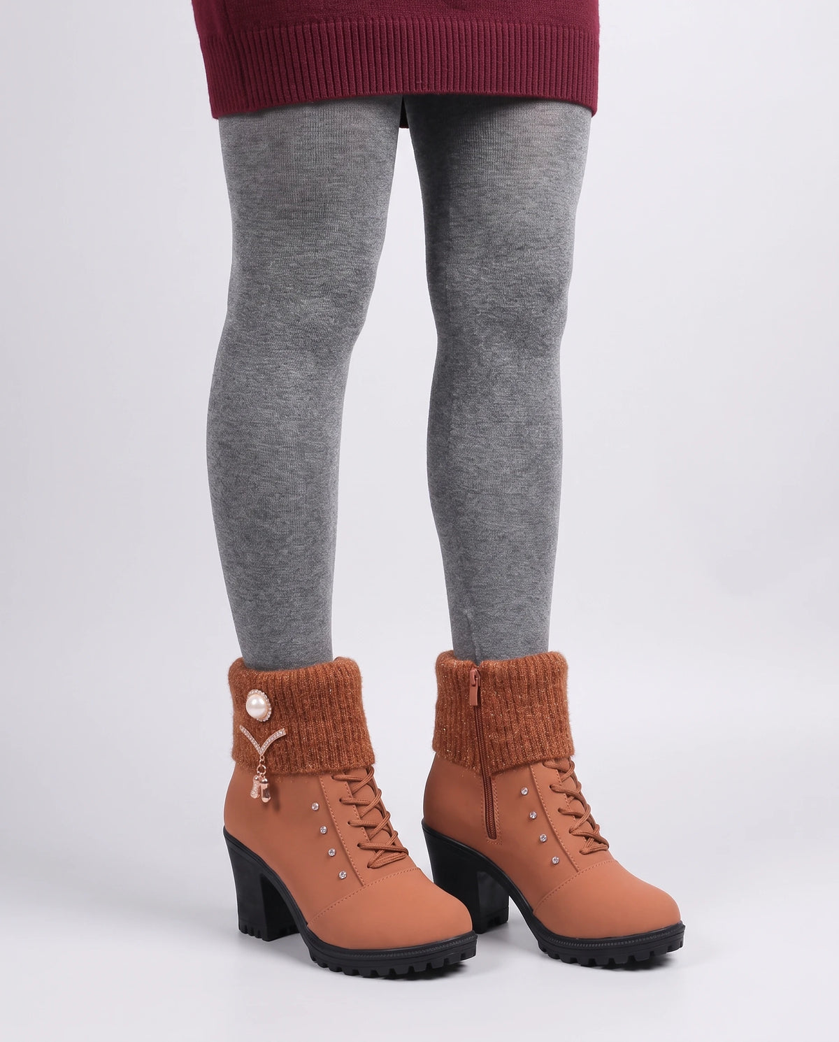 Bottines fourrées à talon et revers en maille Lucrèce — Cognac, portées en plan rapproché sur collants gris, pieds parallèles
