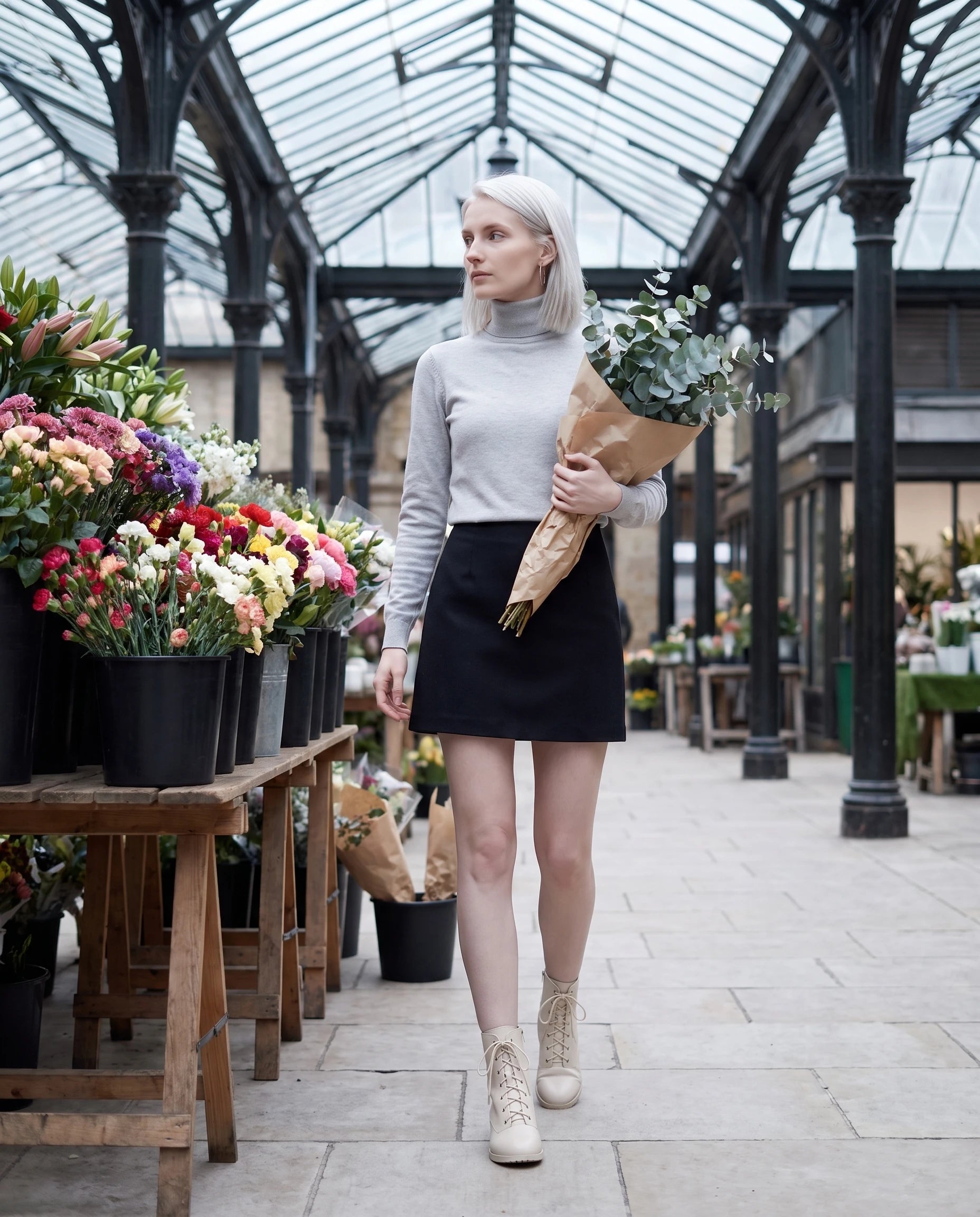 Bottines à lacets à talon effet cuir Alphonsine — Blanc Cassé, portées dans un marché aux fleurs sous halle métallique