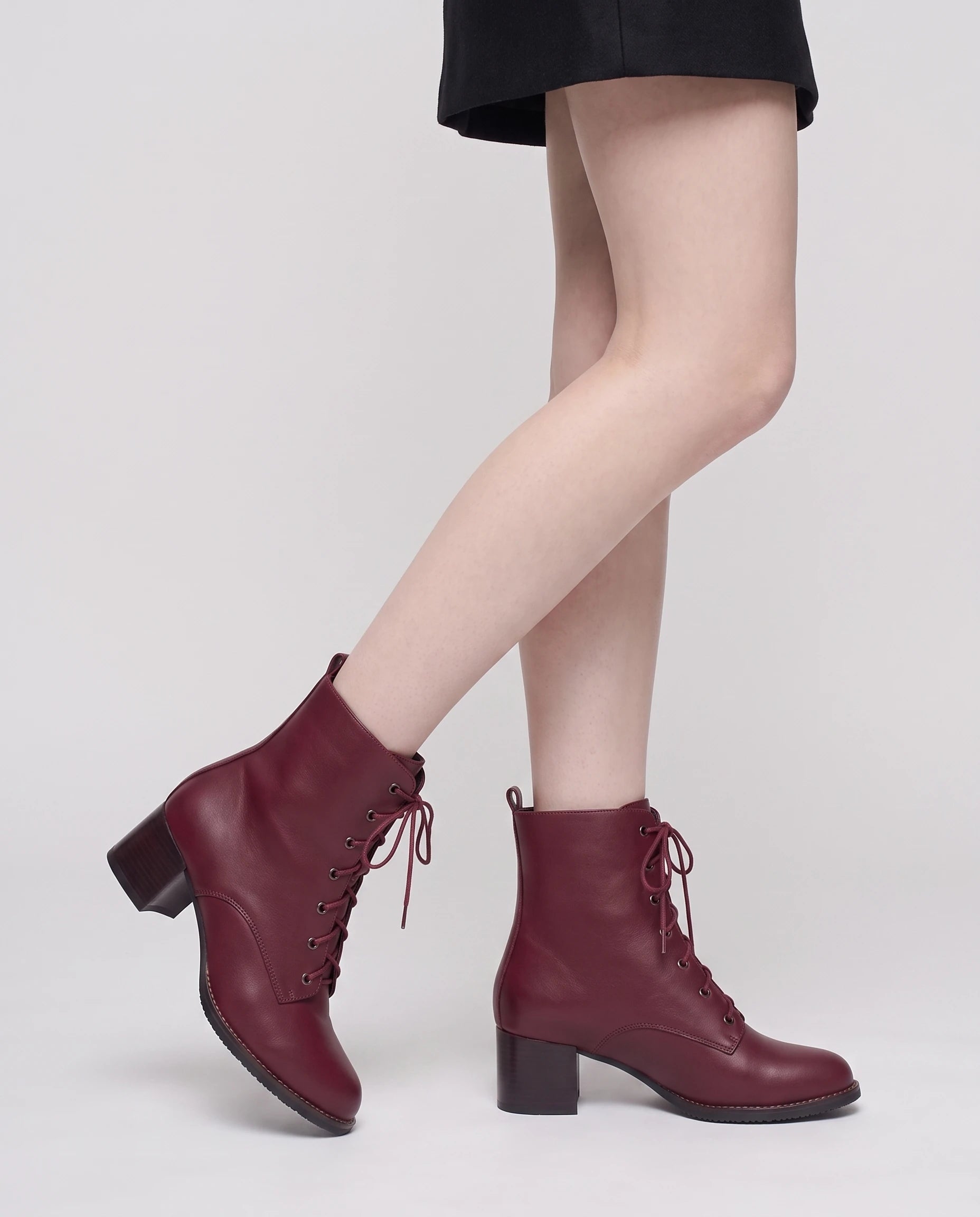 Bottines à lacets à talon effet cuir Alphonsine — Bordeaux, portées en plan rapproché avec une jupe courte