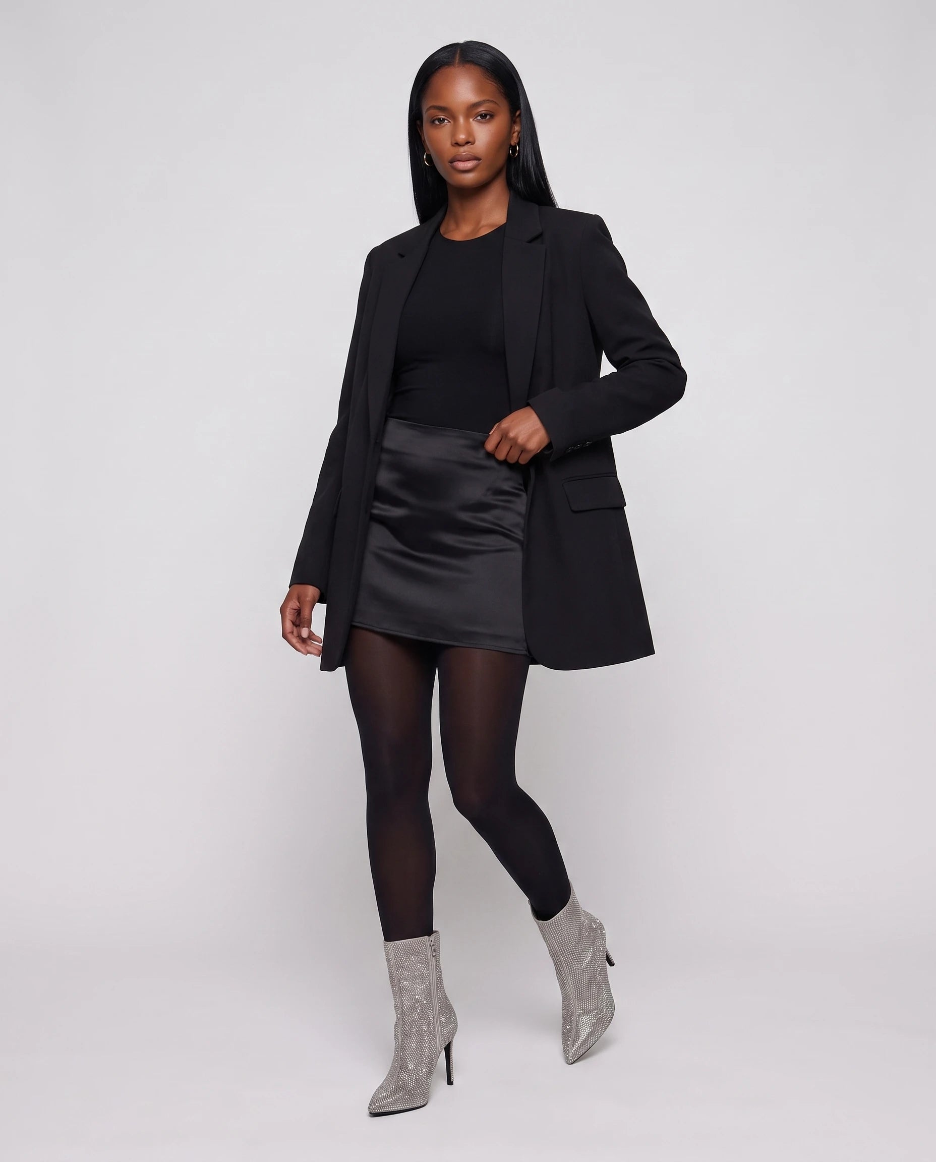 Bottines à strass à talon aiguille Perrette — Argent, portées en plein pied studio avec une jupe en satin et un blazer long