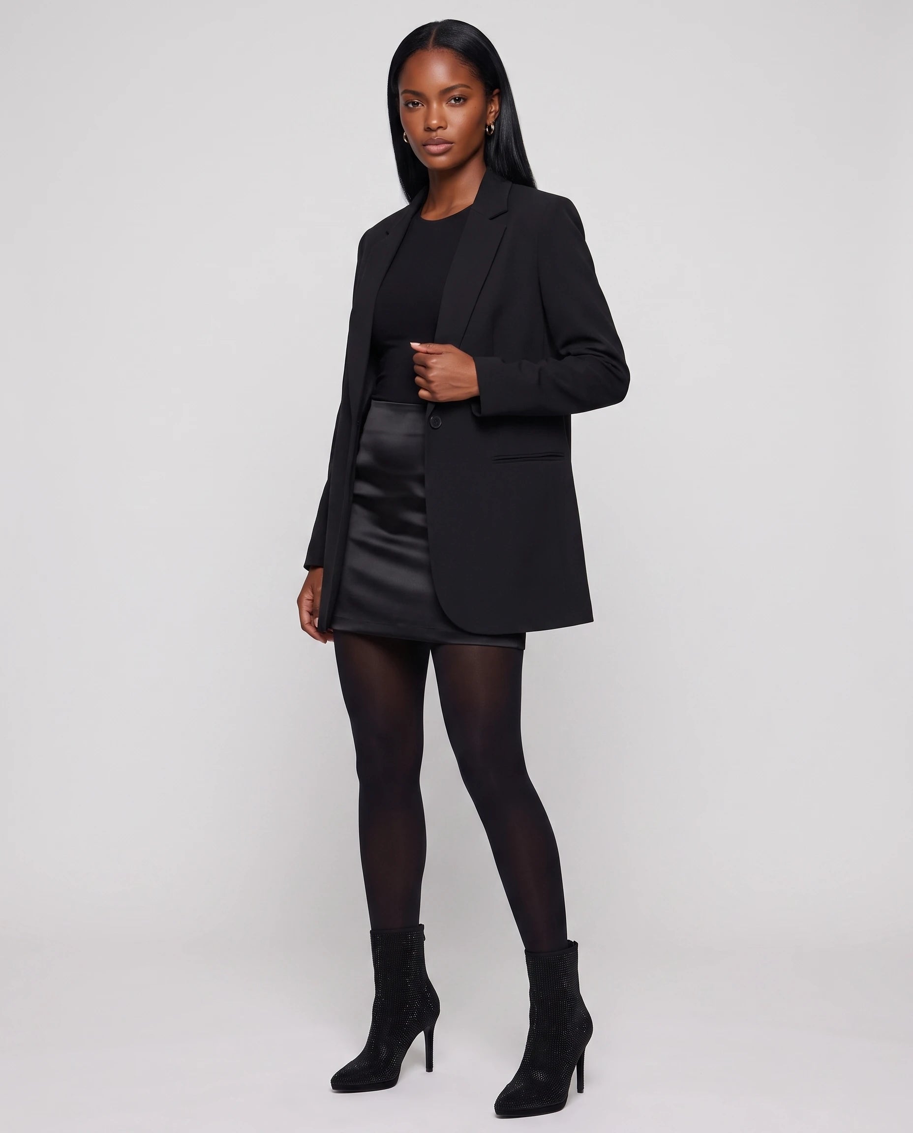 Bottines à strass à talon aiguille Perrette — Noir, portées en plein pied studio avec une jupe en satin et un blazer long