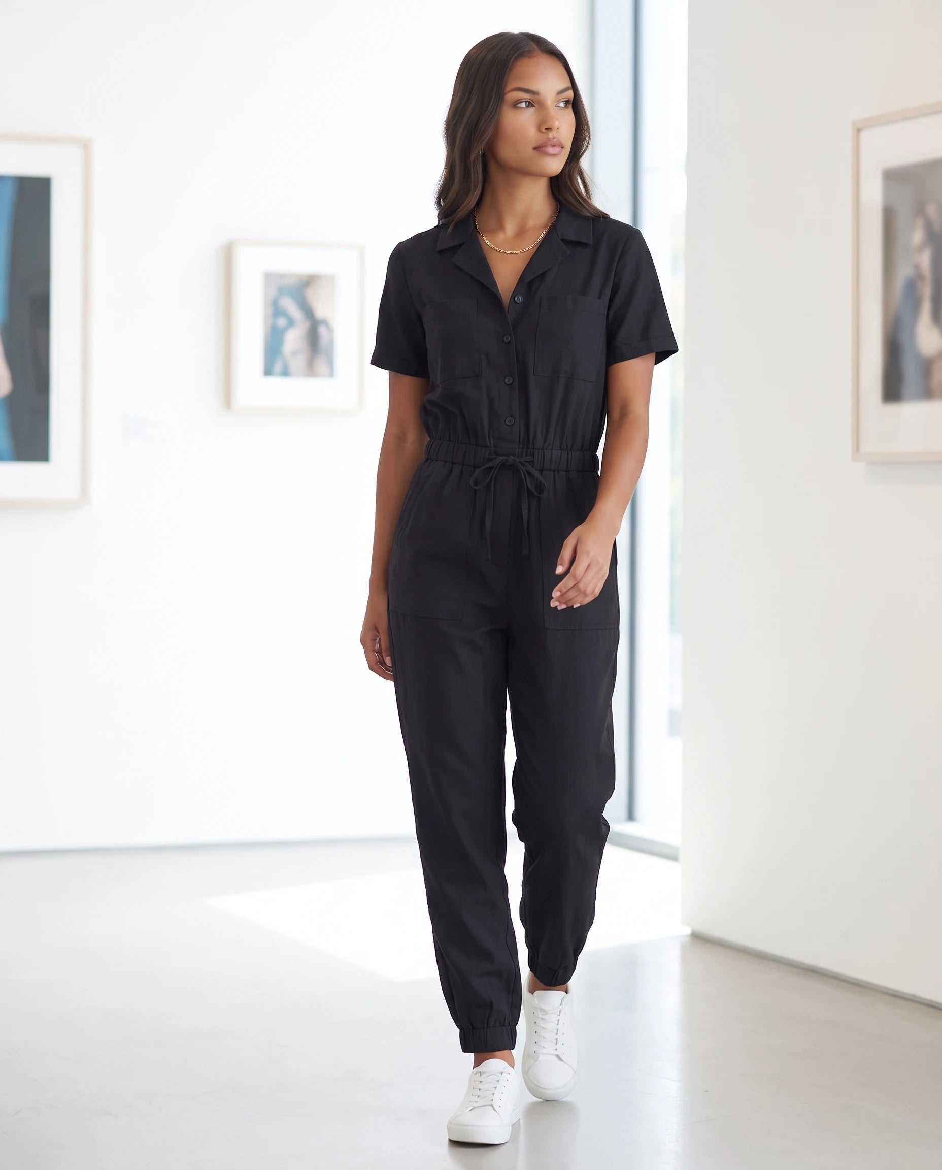 Combinaison cargo boutonnee Marceline en Noir, dans une galerie d art