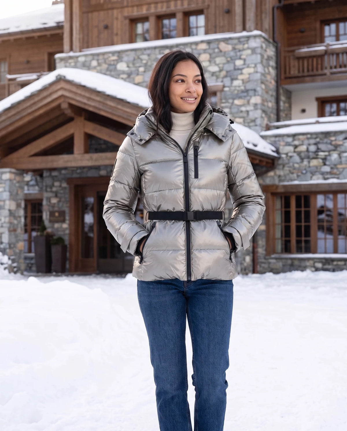 Doudoune cintrée à ceinture Rozenn en Argent, portée devant un hôtel de montagne