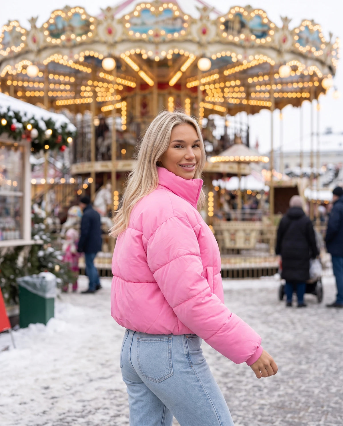 Kurze Steppjacke Odeline in Bonbonrosa, getragen neben einem Winterkarussell