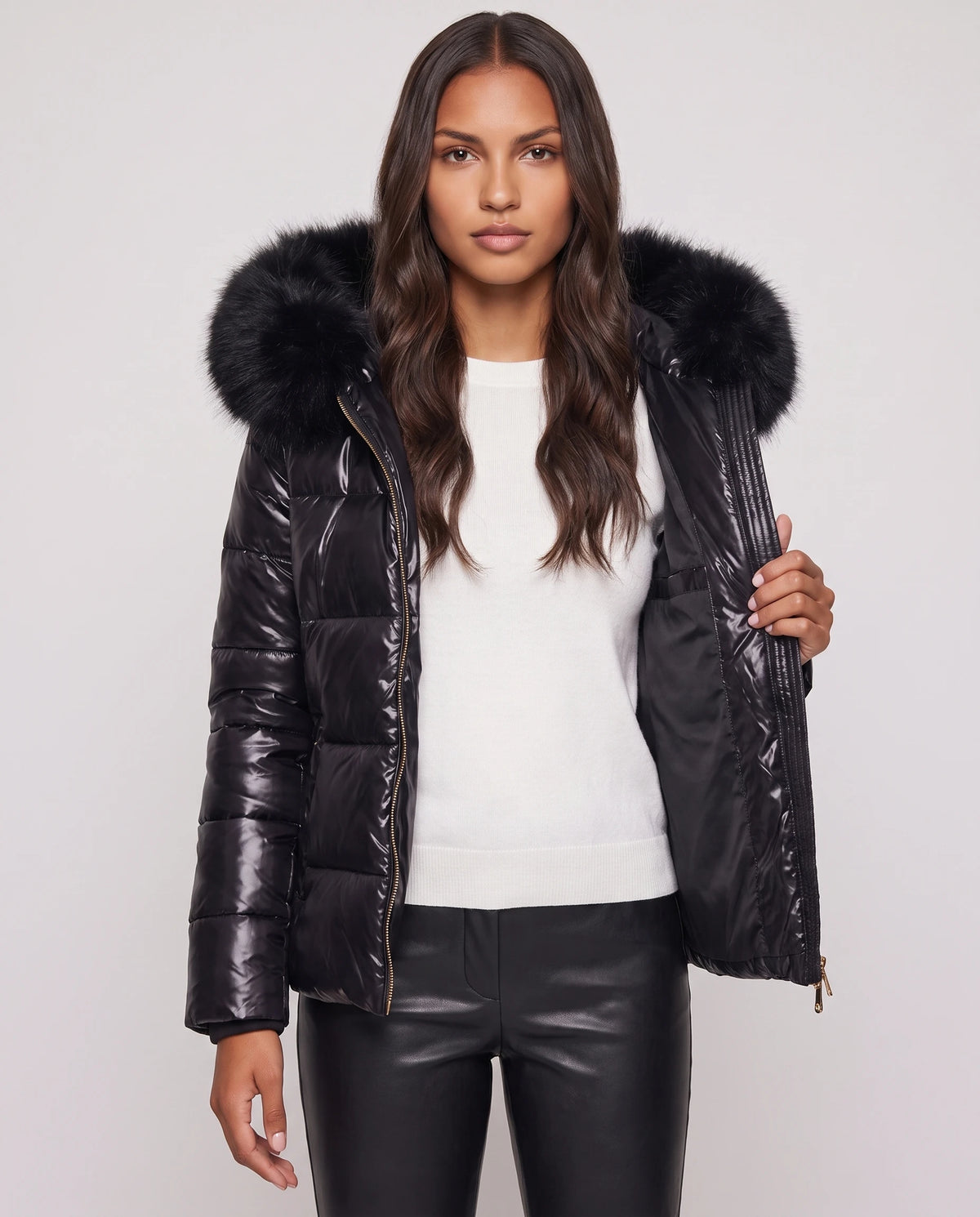 Kurze glänzende Steppjacke mit Kunstfellkapuze Victoria in Schwarz, offen getragen über weissem Pullover