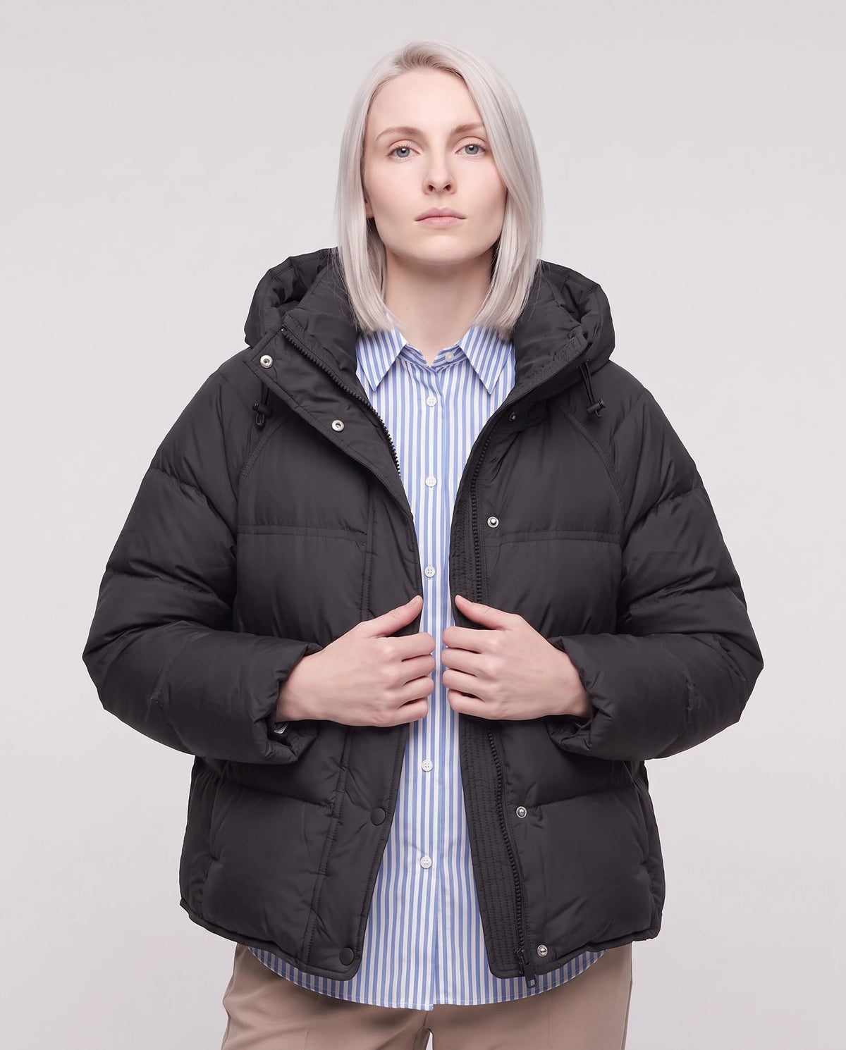 Doudoune courte matelassée à capuche et patte à pressions Ilona noire, portée ouverte sur une chemise rayée, plan rapproché