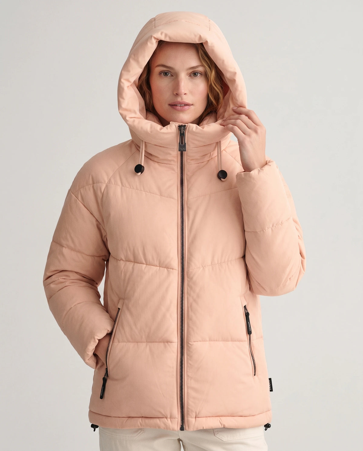 Doudoune courte oversize à capuche Lubine en Rose Pêche, capuche relevée sur la tête, visage dégagé