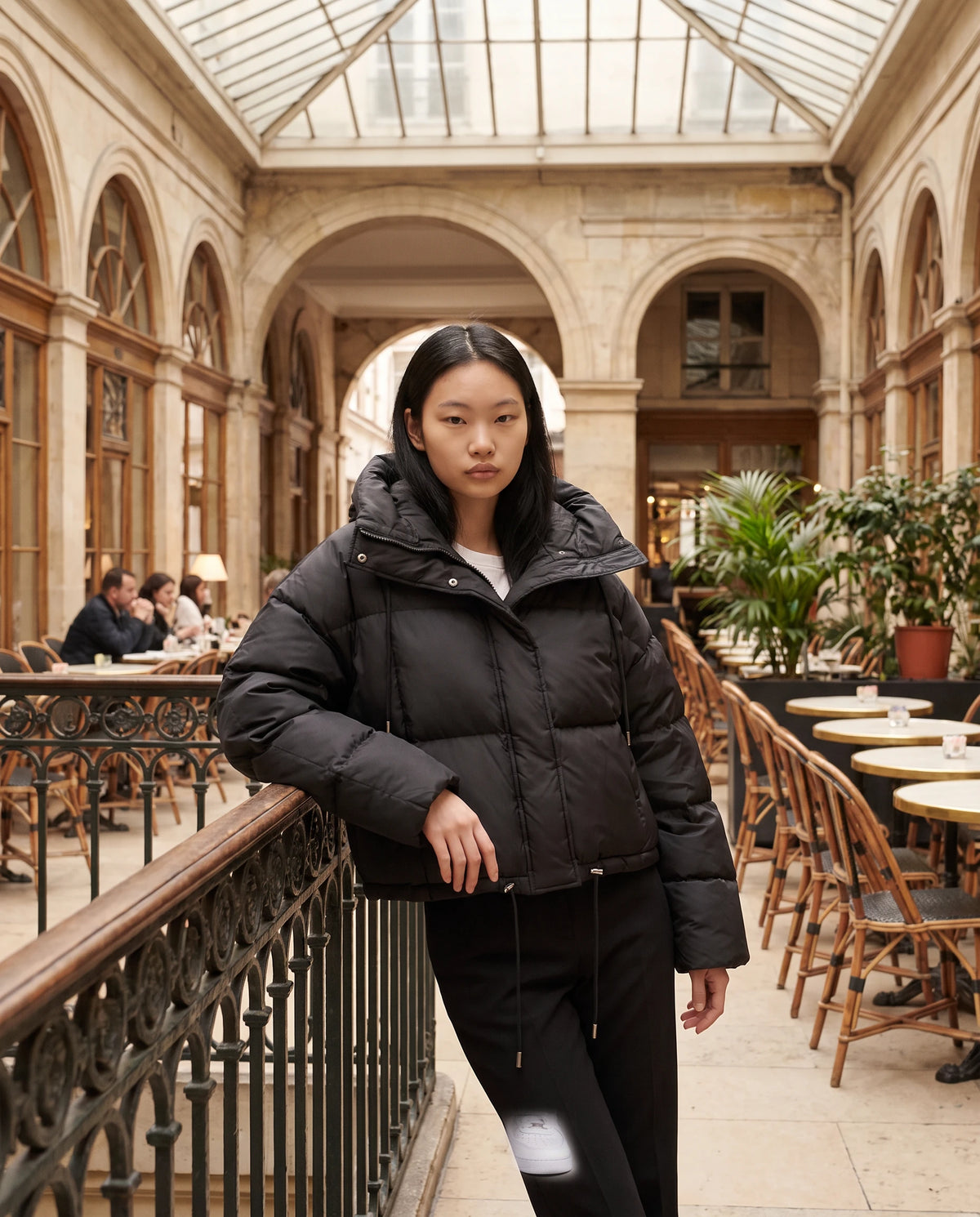 Cropped Pufferjacke Sabelline in Schwarz, getragen in einer überdachten Passage