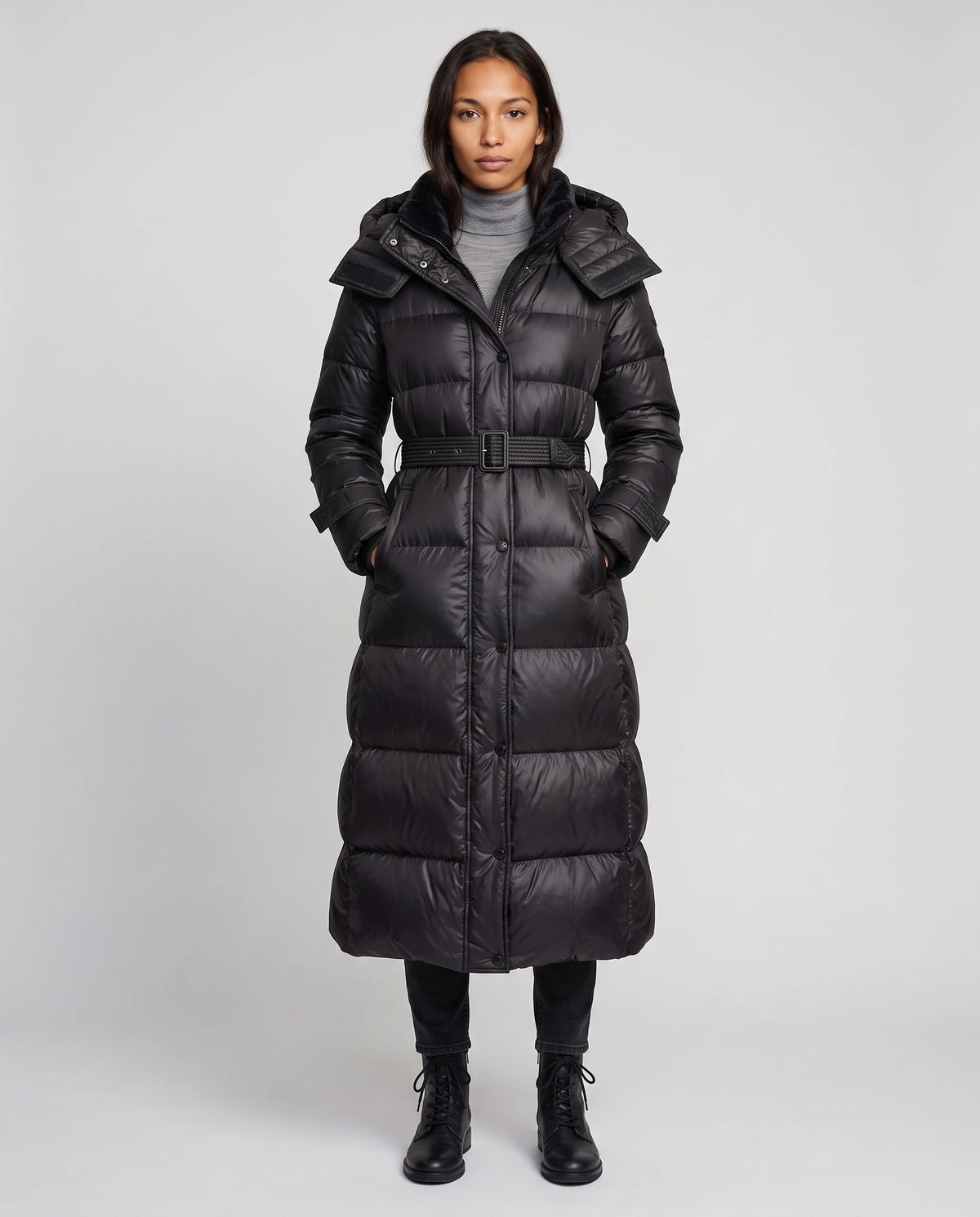 Doudoune extra-longue brillante à capuche et ceinture à boucle Carole en Noir, vue de face en pied, pressionnée, ceinture bouclée, capuche baissée