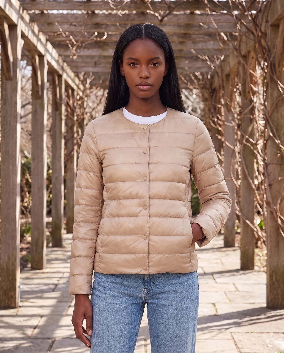 Leichte dünne Steppjacke mit Rundhals Sophie in Beige, getragen unter einer Pergola