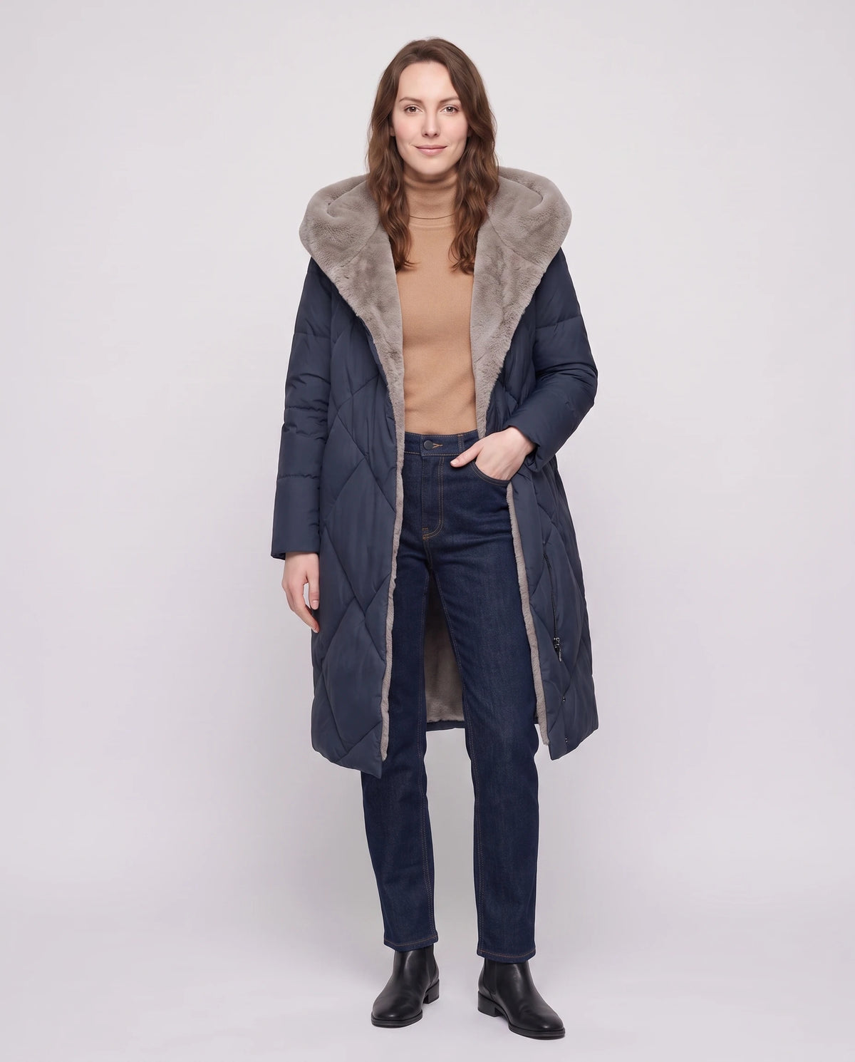 Lange Steppjacke mit kunstfellgefütterter Kapuze Nadia in Marineblau, offen getragen über camelfarbenem Rollkragenpullover