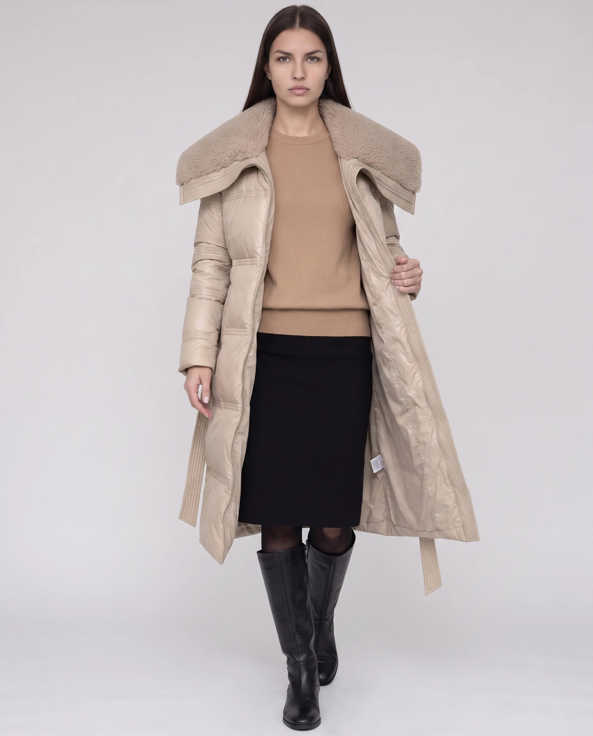 Doudoune longue ceinturée à col fausse fourrure Auriane en Beige, portée ouverte sur un pull camel, ceinture libre