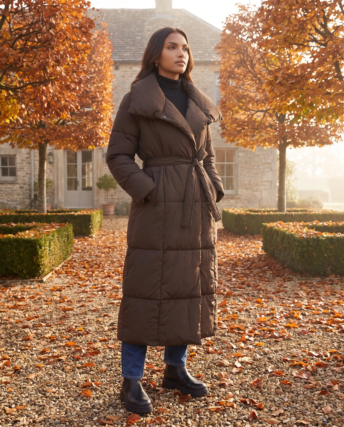 Doudoune longue matelassée Eudeline en Chocolat portée dans une cour en automne
