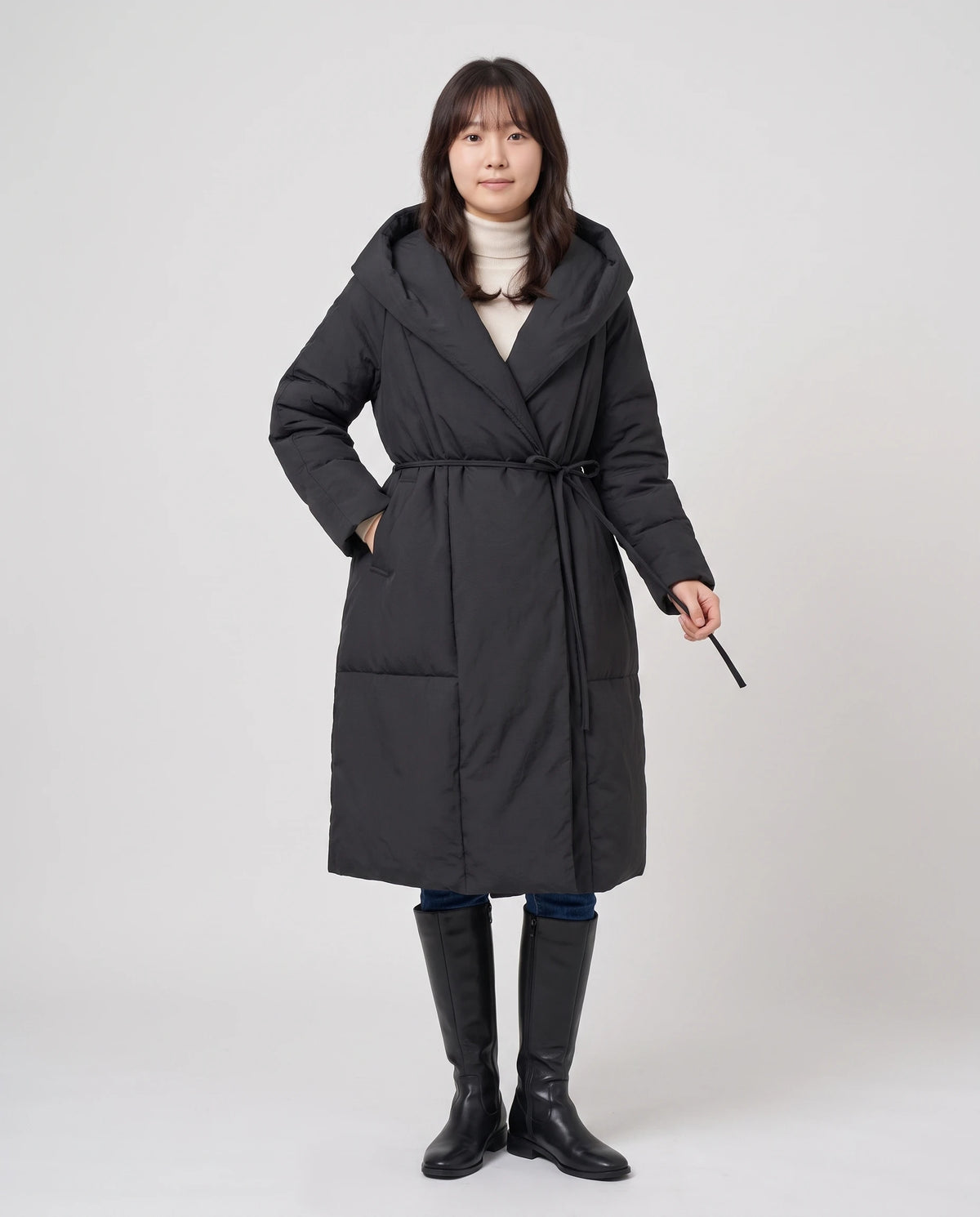 Langer Wickel-Steppmantel mit Oversize-Kapuze Aurélia in Schwarz, Vorderansicht in ganzer Länge, Gürtel gebunden, Kapuze als Schalkragen