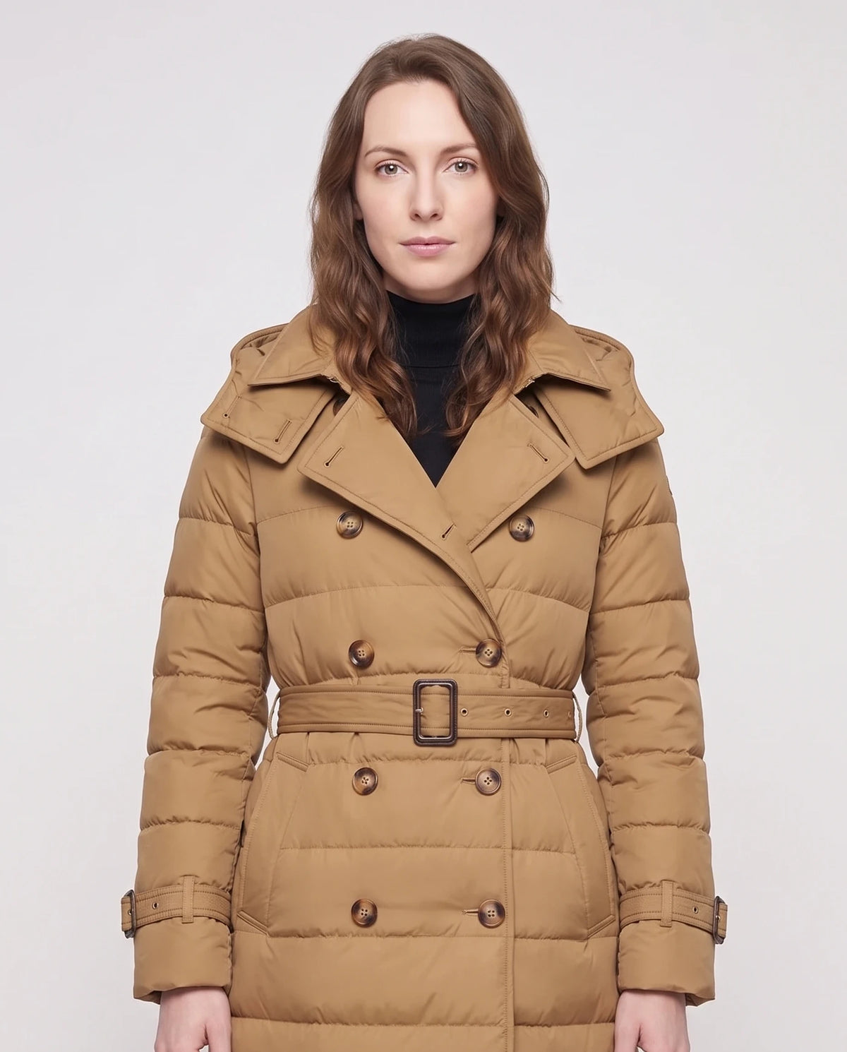 Doudoune longue façon trench à capuche et double boutonnage Rachel en Camel, plan rapproché, col revers, boutons écaille, boucle et patte de poignet