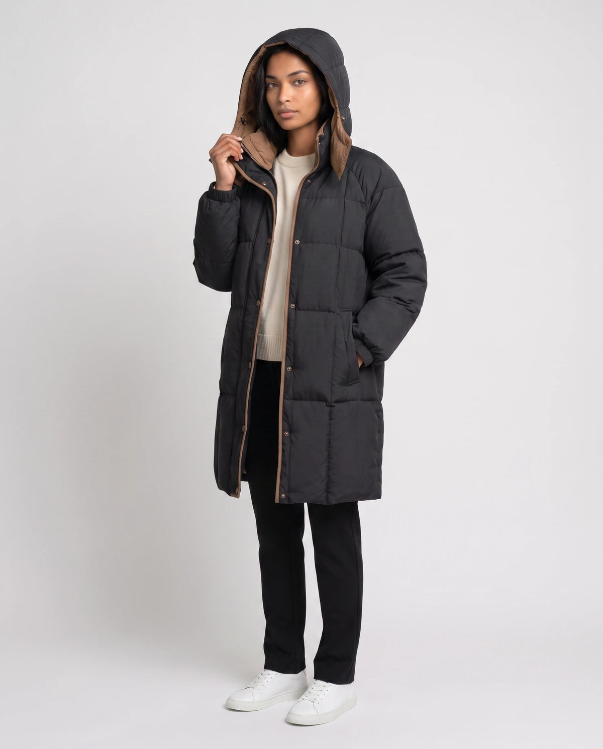 Mittellange Winterjacke mit Kapuze und Kontrastfutter Alexia in Schwarz, Dreiviertelansicht, Kapuze aufgesetzt mit camelfarbenem Futter