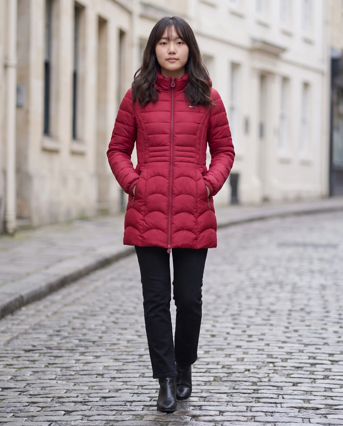 Doudoune mi-longue cintrée à capuche Angeline rouge profond, rue pavée en hiver, mains dans les poches