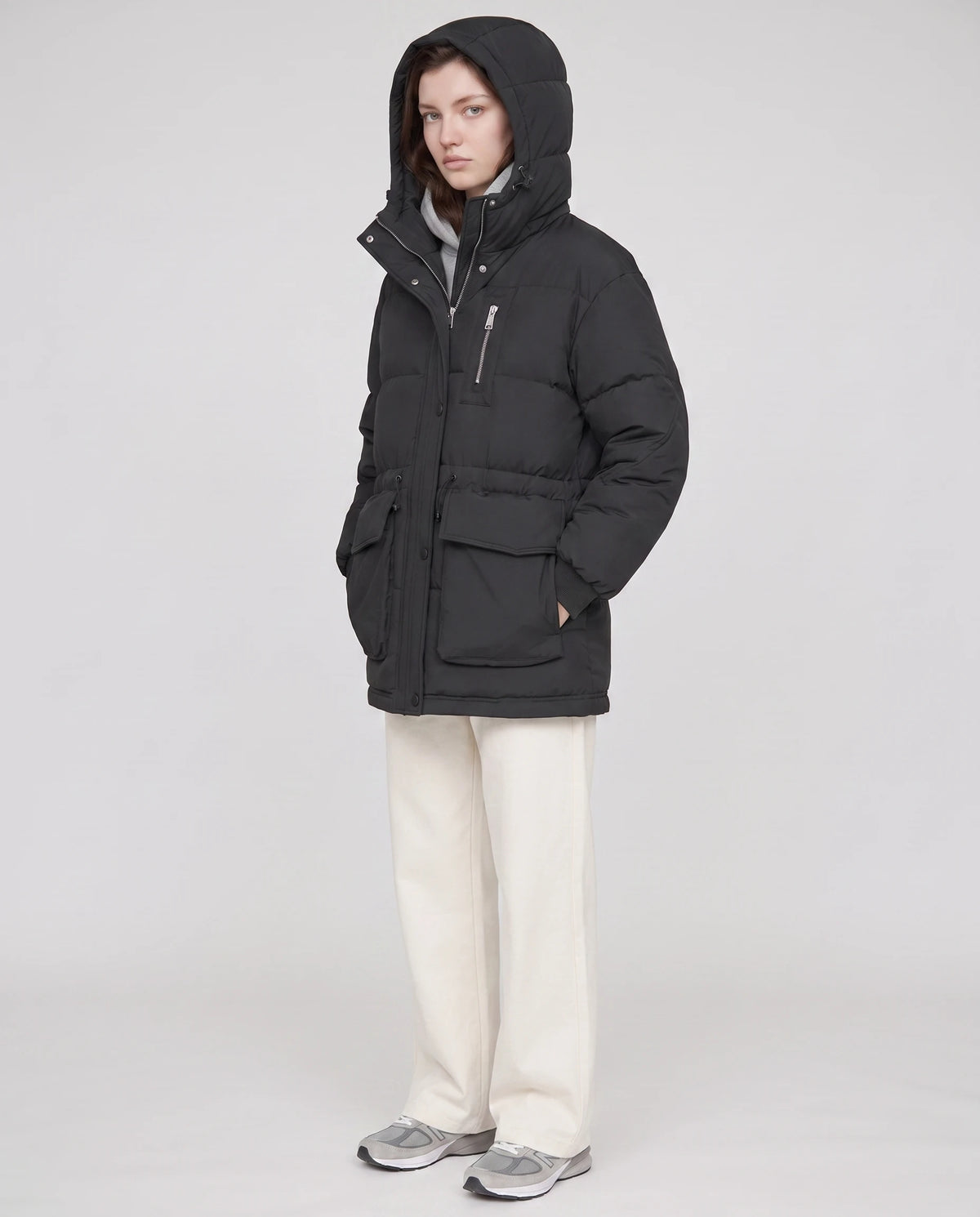 Mittellange Parka-Steppjacke mit Pattentaschen Muriel in Schwarz, Dreiviertelansicht, Kapuze aufgesetzt