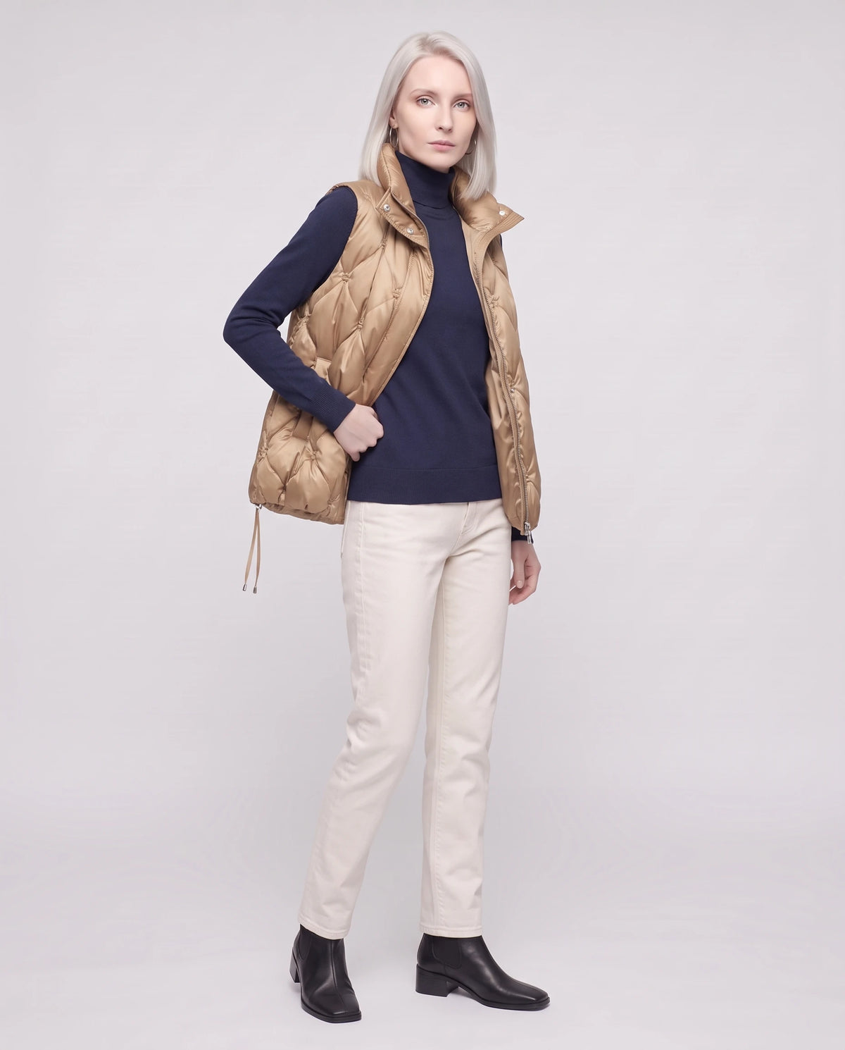 Doudoune sans manches capitonnée en satin Marielle, coloris Beige Doré, portée ouverte de trois quarts sur un col roulé marine
