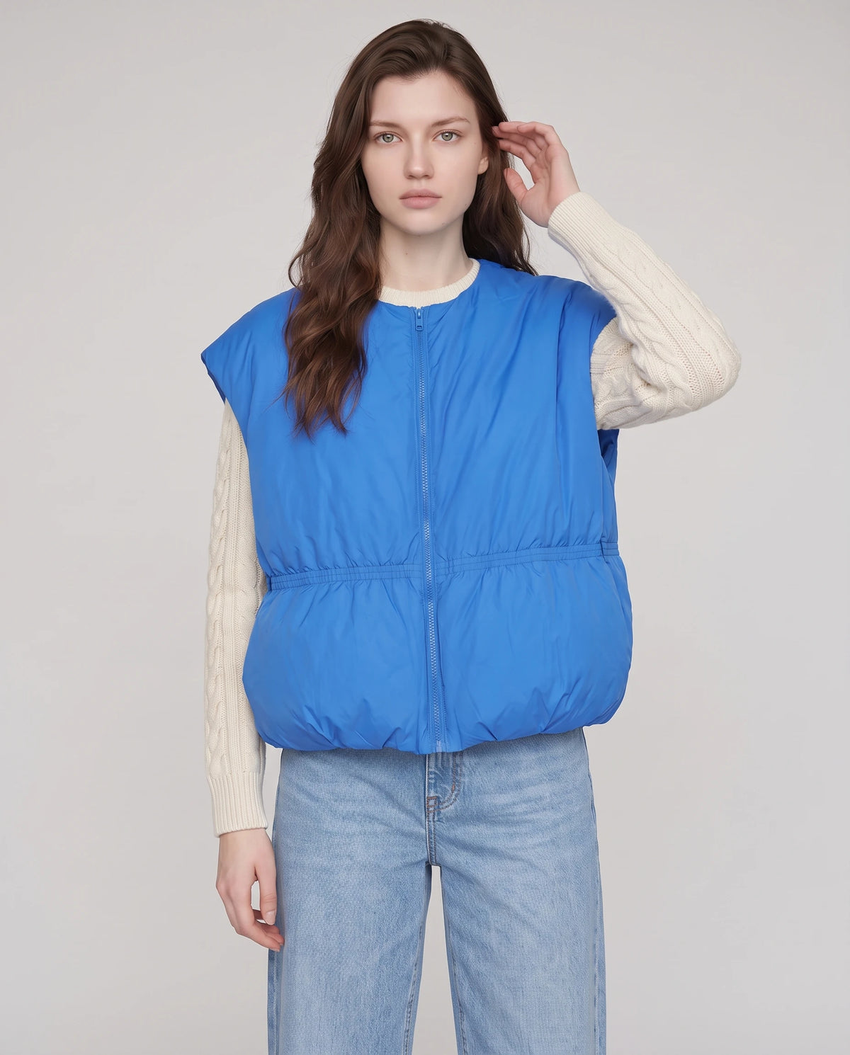 Doudoune sans manches cocon à col rond Béatrix, coloris Bleu Azur, plan rapproché de face, main qui replace une mèche