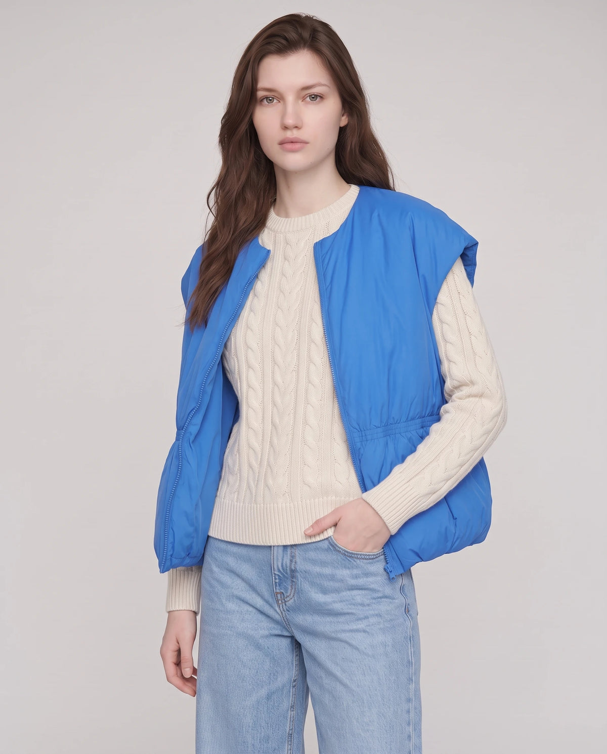 Doudoune sans manches cocon à col rond Béatrix, coloris Bleu Azur, portée ouverte de trois quarts sur un pull écru