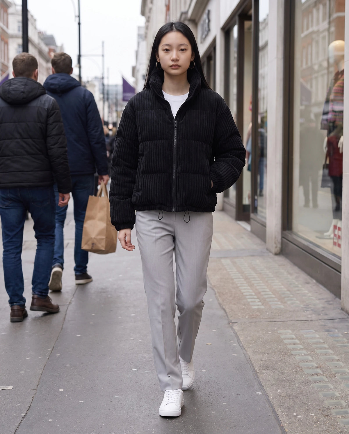 Doudoune courte en velours côtelé Lucia en Noir, portée dans une rue commerçante