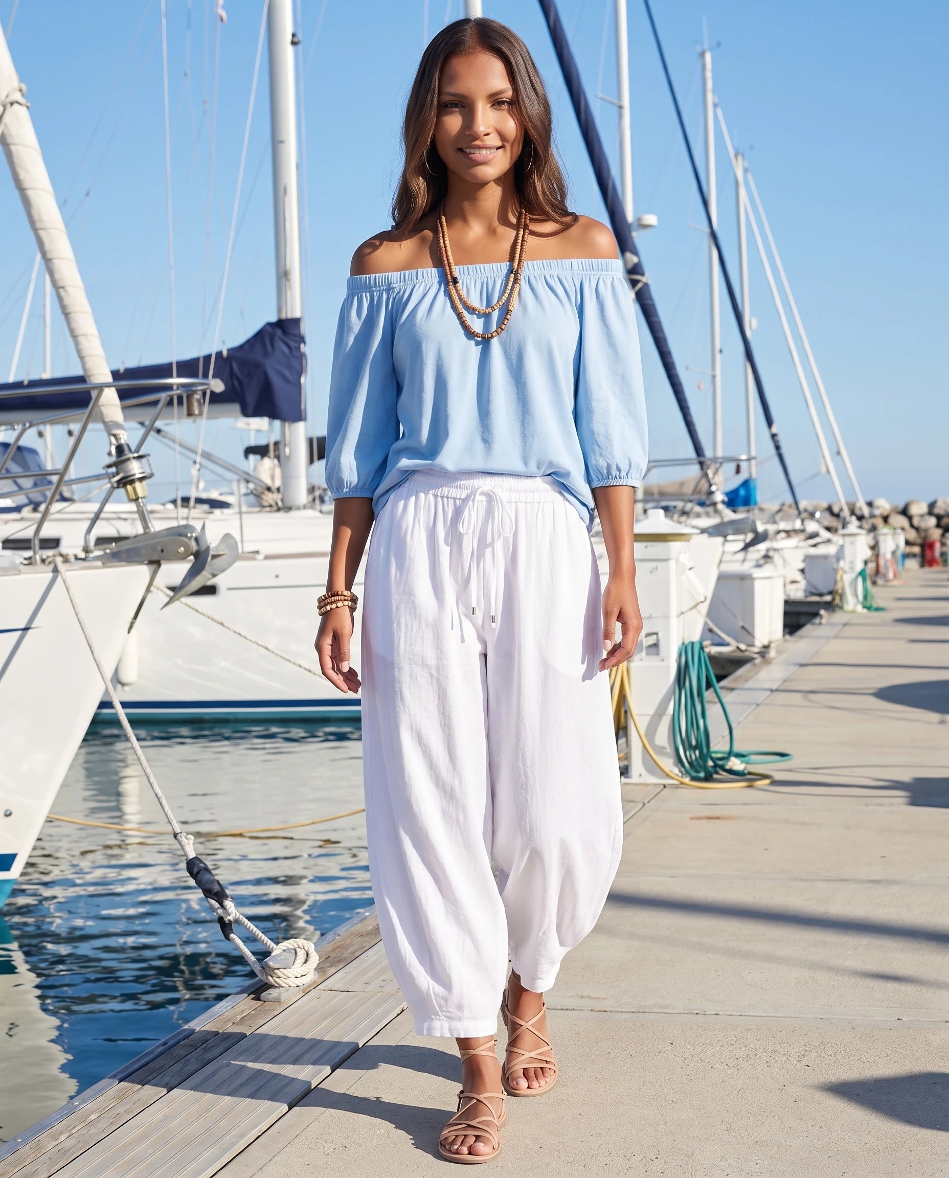 Ensemble epaules denudees et pantalon sarouel Bleu Ciel portee dans une marina aux voiliers blancs - Lorene | Zolena