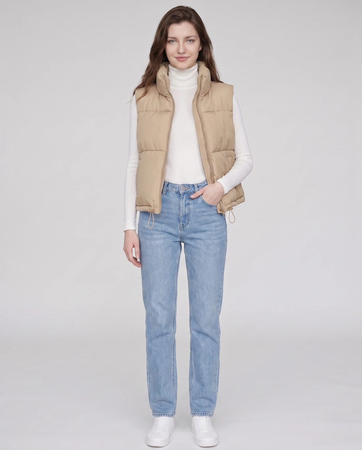 Gilet matelassé cropped à col montant et ourlet à cordon Lydie en Beige, porté ouvert sur un col roulé blanc, zip descendu