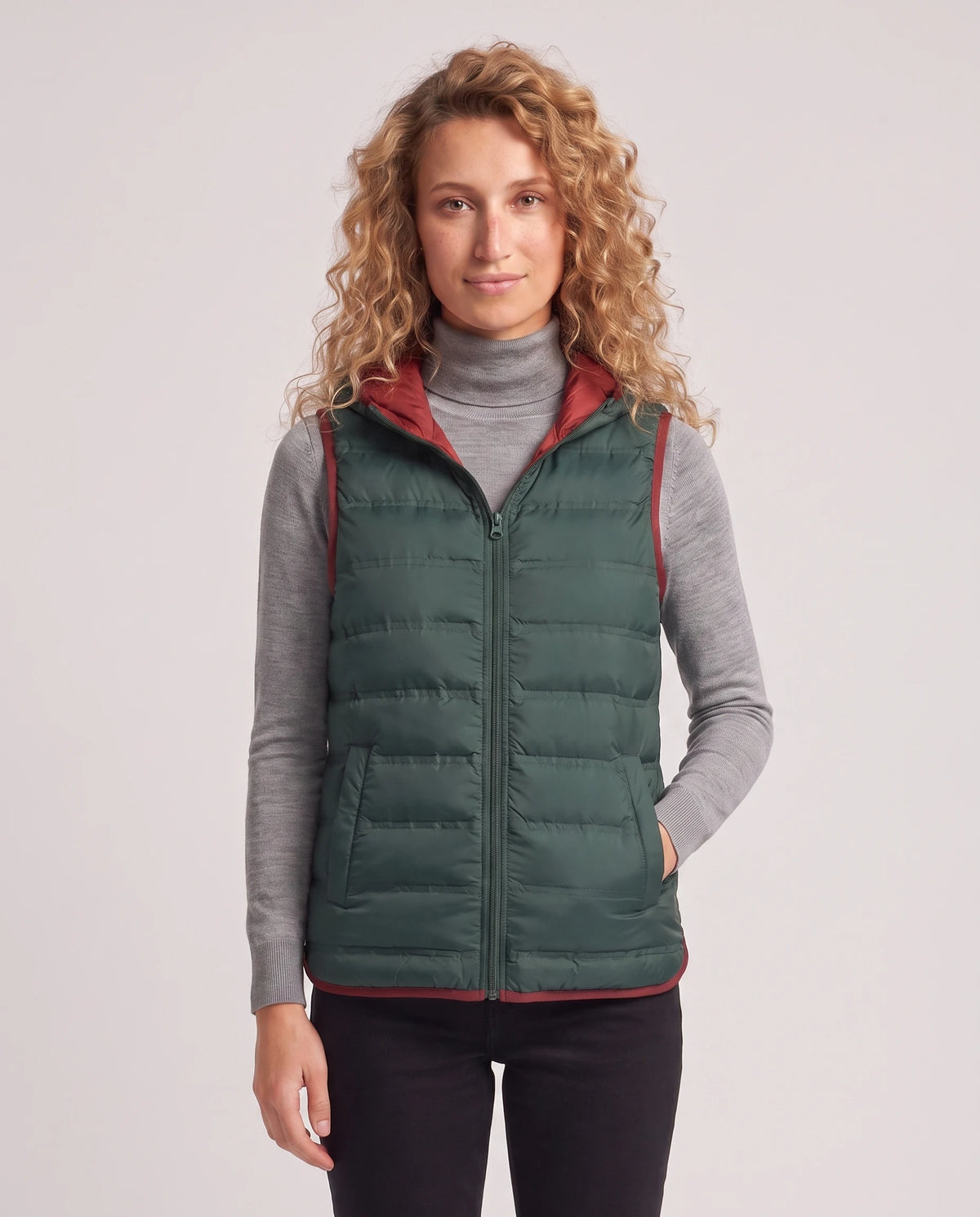 Gilet matelassé léger à capuche et doublure contrastée Laurence en Vert Sapin, plan rapproché, zippé au menton, capuche baissée