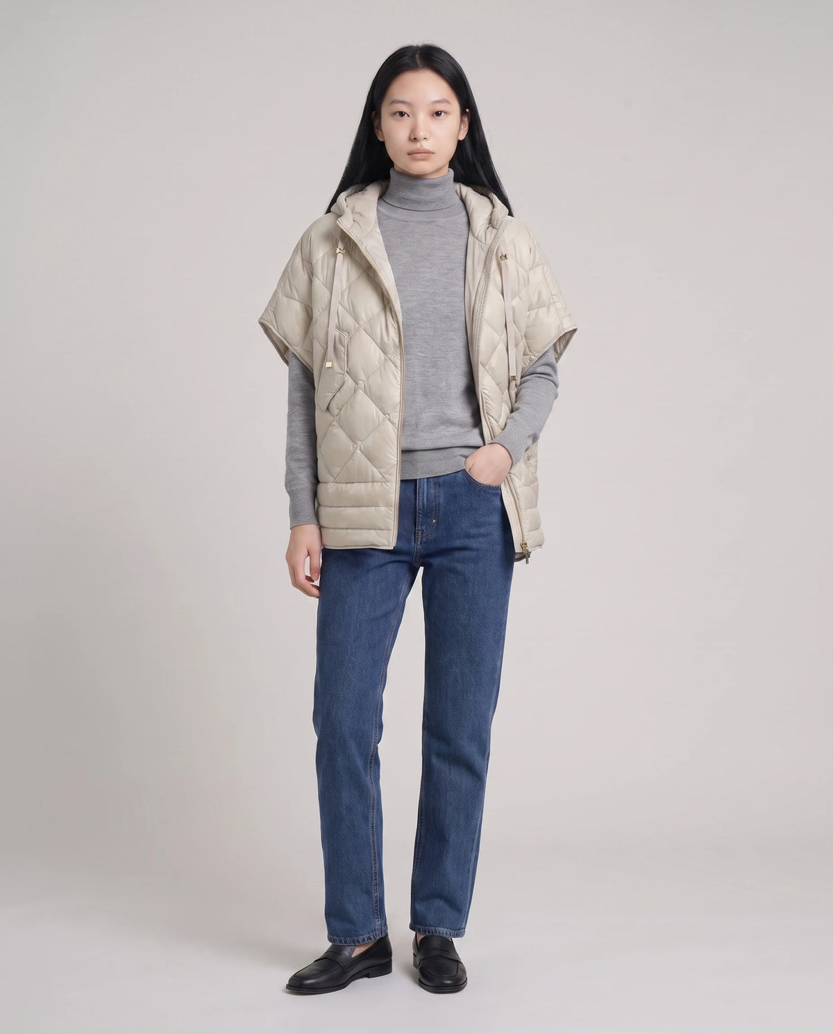 Gilet matelassé à capuche et pressions Céline en Beige, porté ouvert sur un col roulé gris chiné, en pied