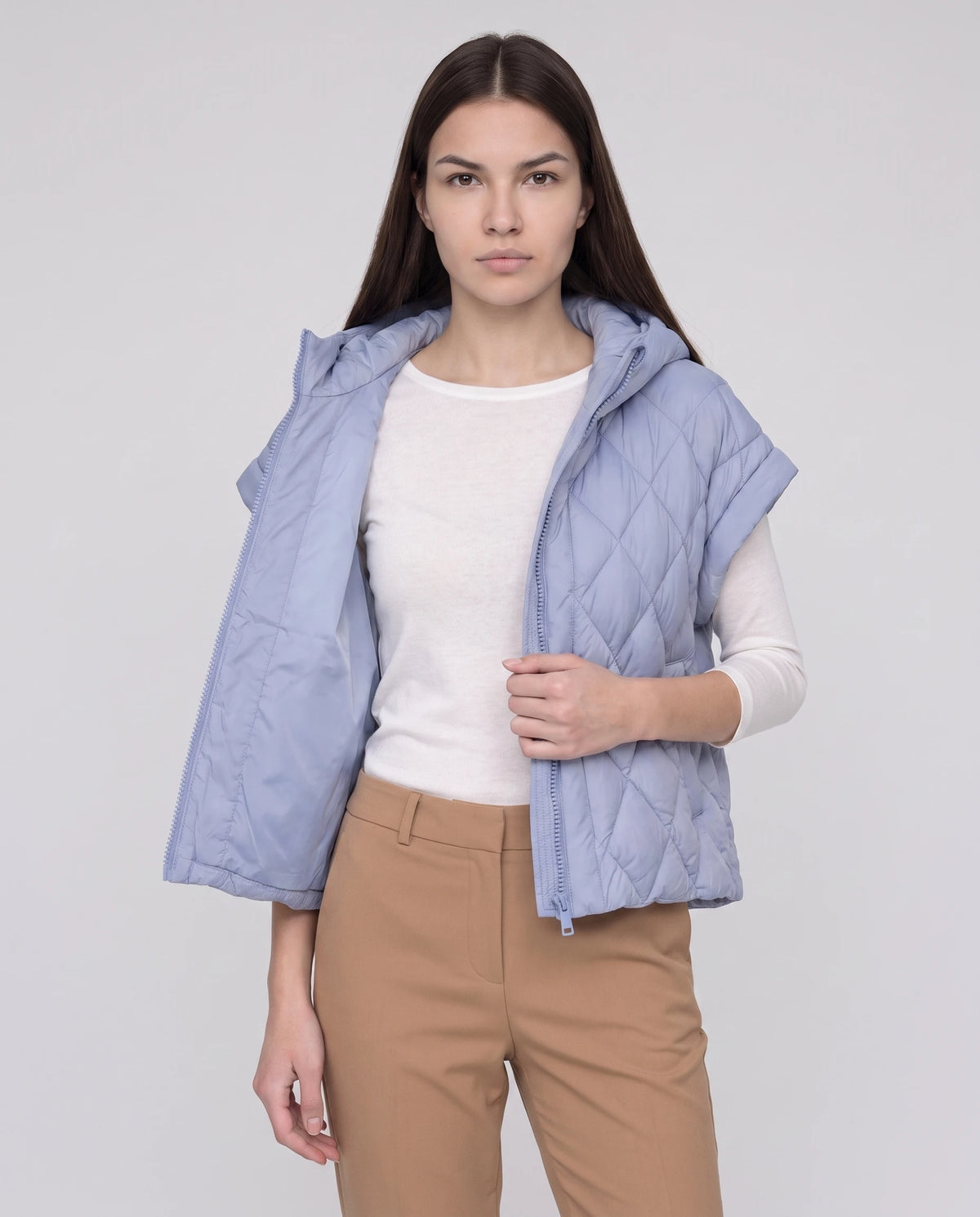 Gilet matelassé court à capuche Mia en Bleu Pervenche, porté ouvert sur un top blanc, plan rapproché