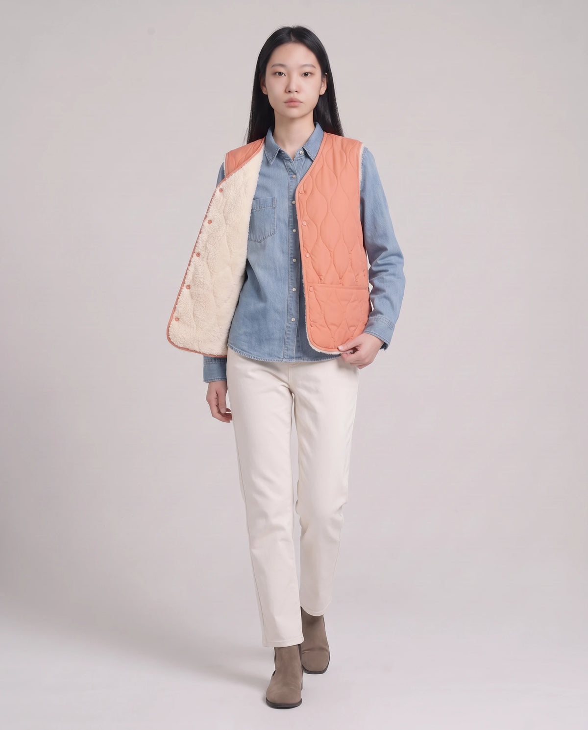 Gilet matelassé doublé sherpa à col V Amaline — Corail, porté ouvert sur une chemise en jean, doublure sherpa visible