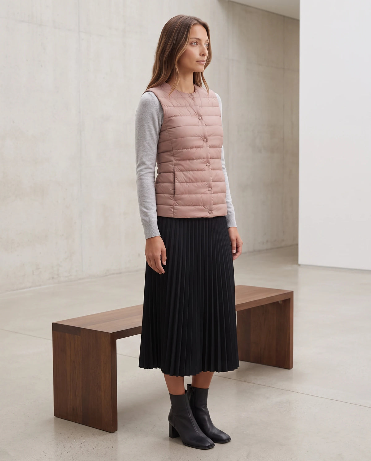 Gilet ultra-léger à col rond transformable Valérie en Rose Nude, porté dans une galerie aux murs clairs