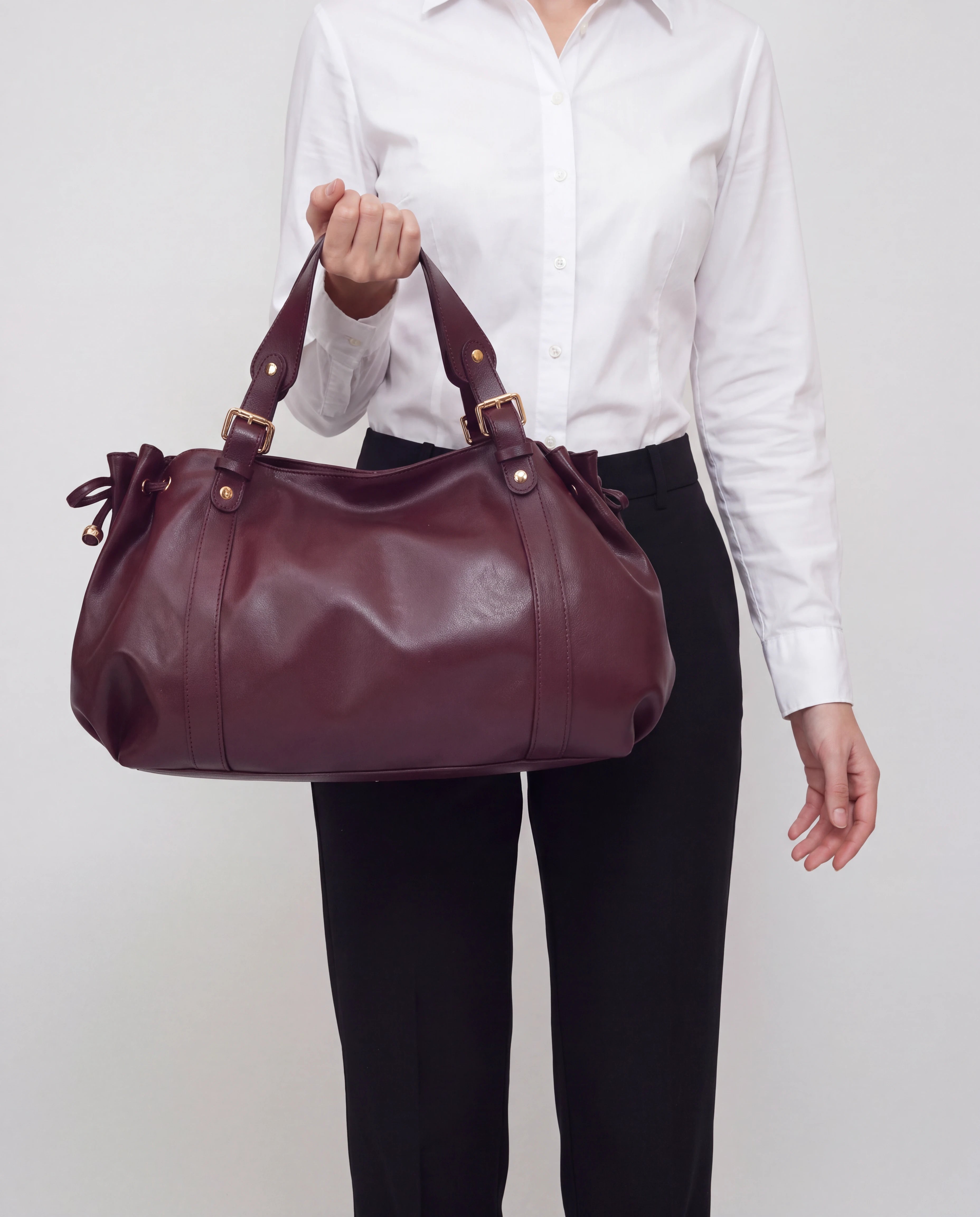 Grand sac à main de cours bowling souple Enora coloris Bordeaux — porté à la main, bras le long du corps