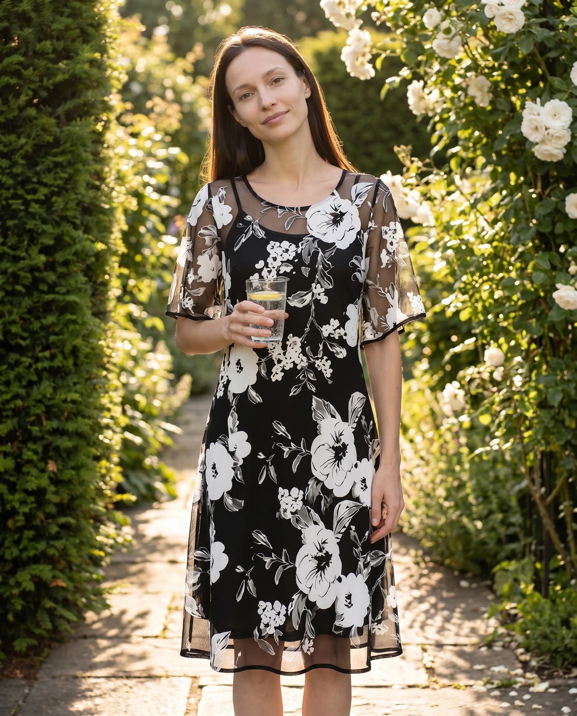 Robe Sidonie noire portee dans un jardin de roses