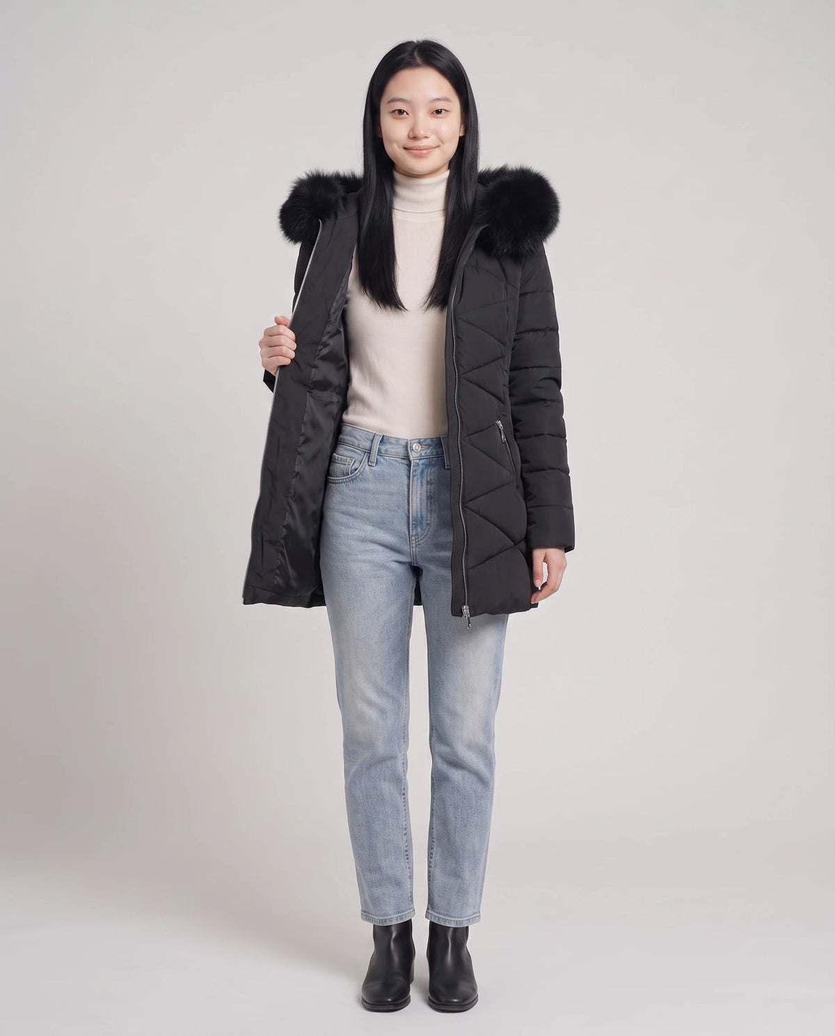 Parka mi-longue cintrée à capuche fausse fourrure Paola en Noir, portée ouverte sur un col roulé crème