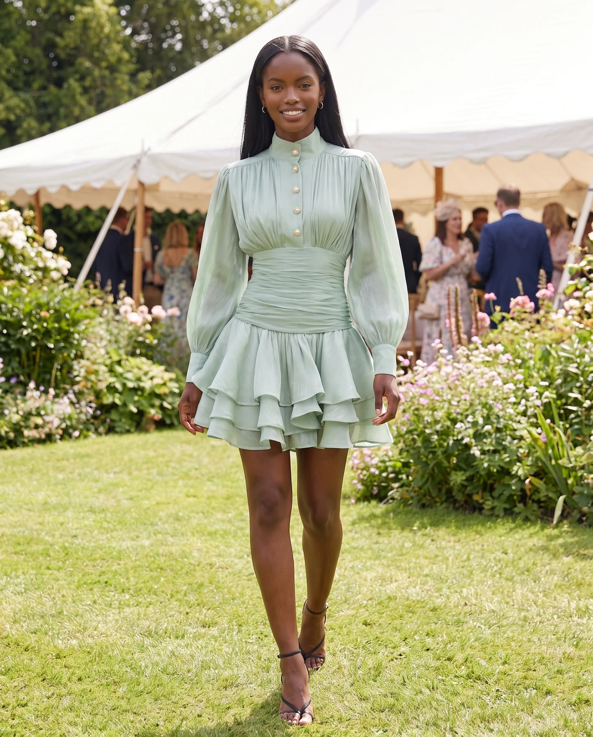 Robe courte à col montant et manches ballon Bianca en Vert Amande, portée dans un jardin en fête
