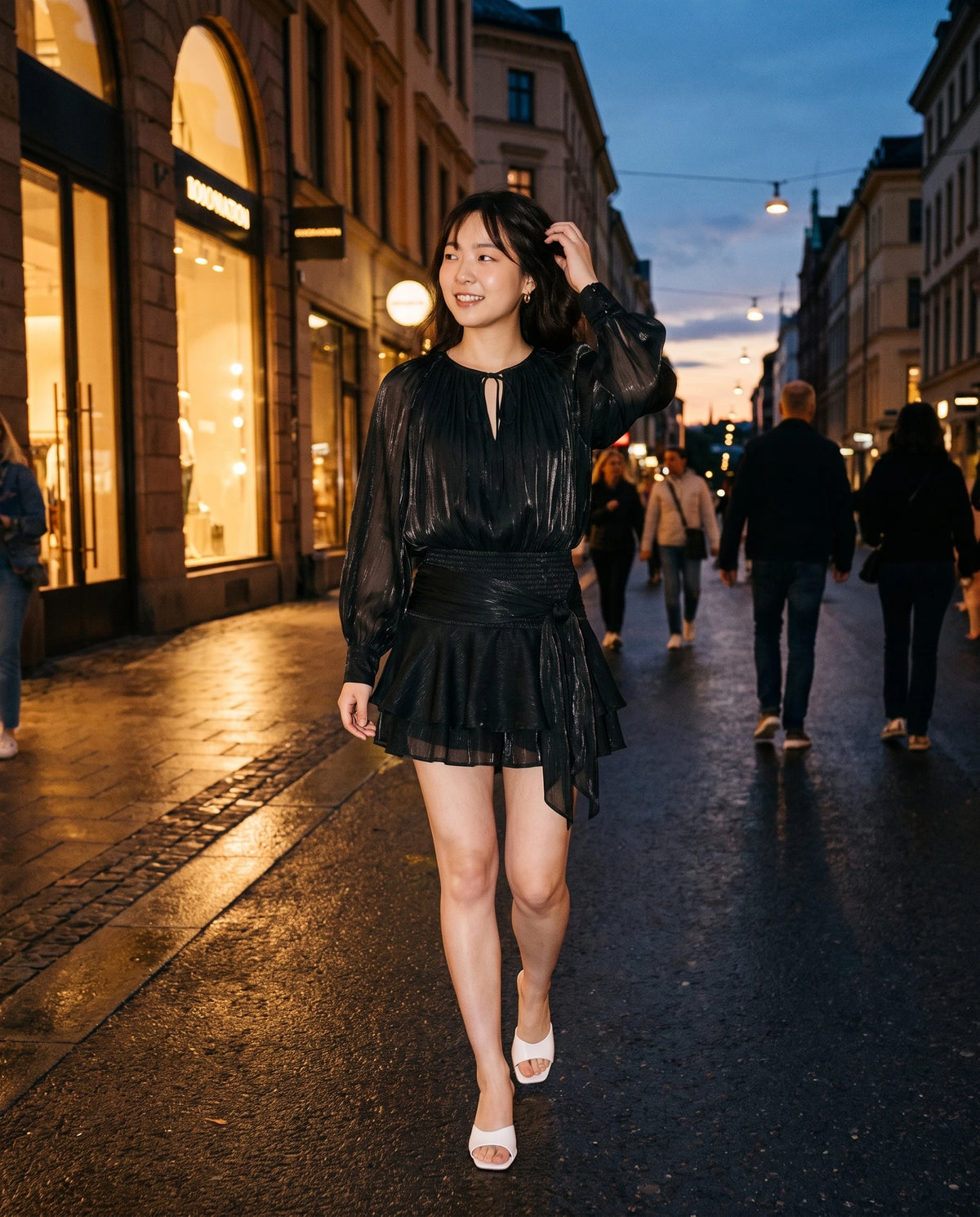 Robe courte tunique en mousseline à manches ballon Louna en Noir, portée dans une rue au crépuscule