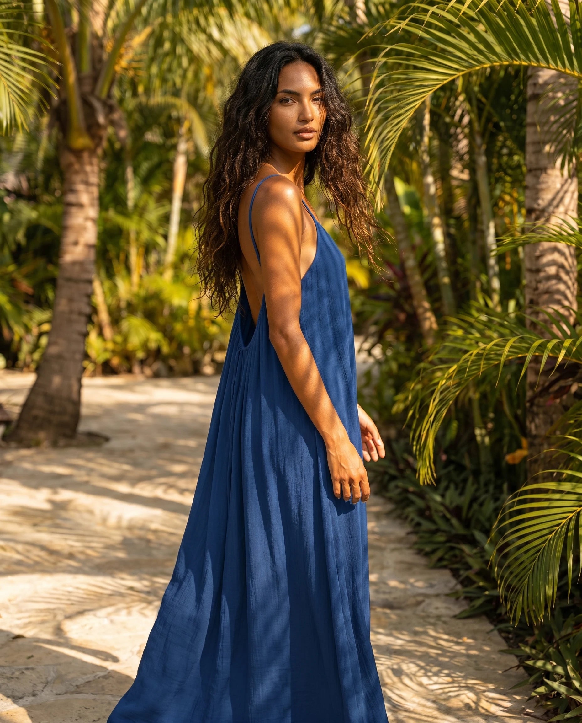 Robe longue trapèze dos nu bleu saphir Zolena, vue de dos en allee tropicale