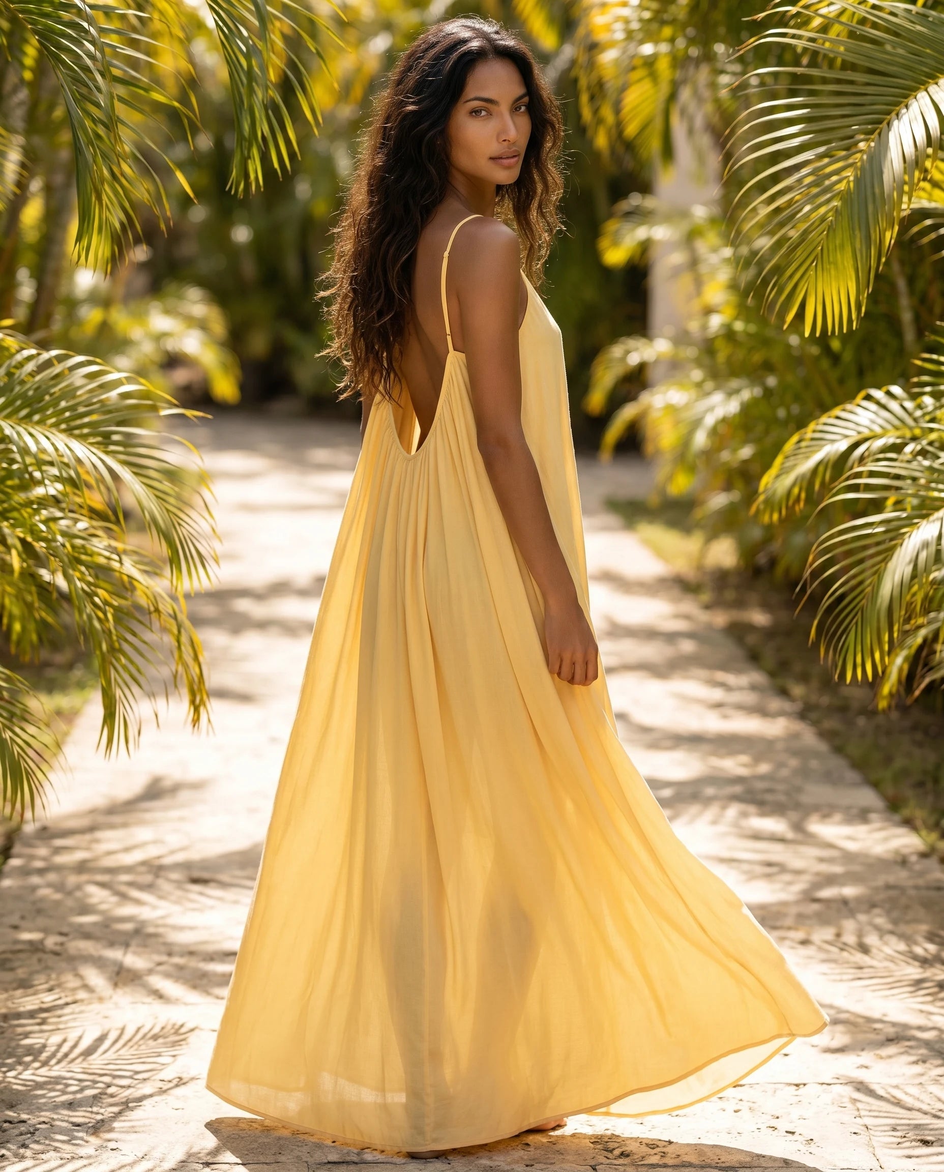 Robe longue trapèze dos nu jaune printemps Zolena, vue de dos en allee tropicale