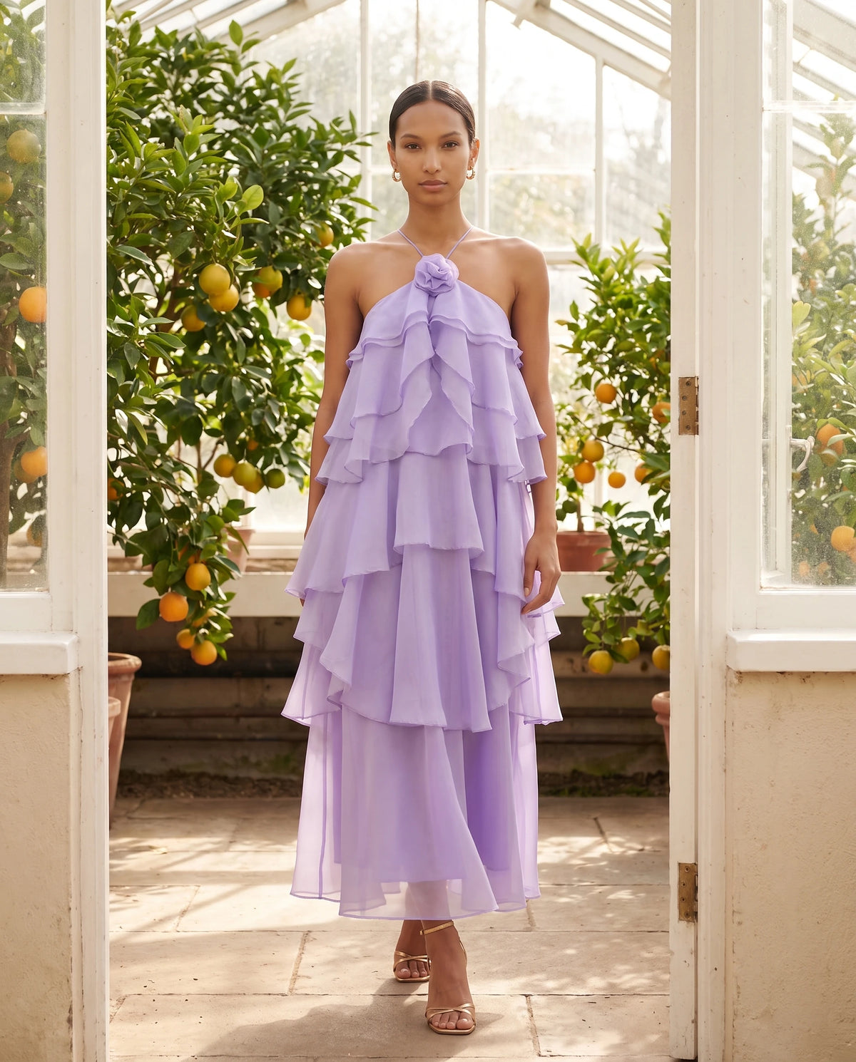 Langes Neckholder-Kleid aus Organza mit Stufenvolants Iliana in Lavendel, in einer Orangerie getragen